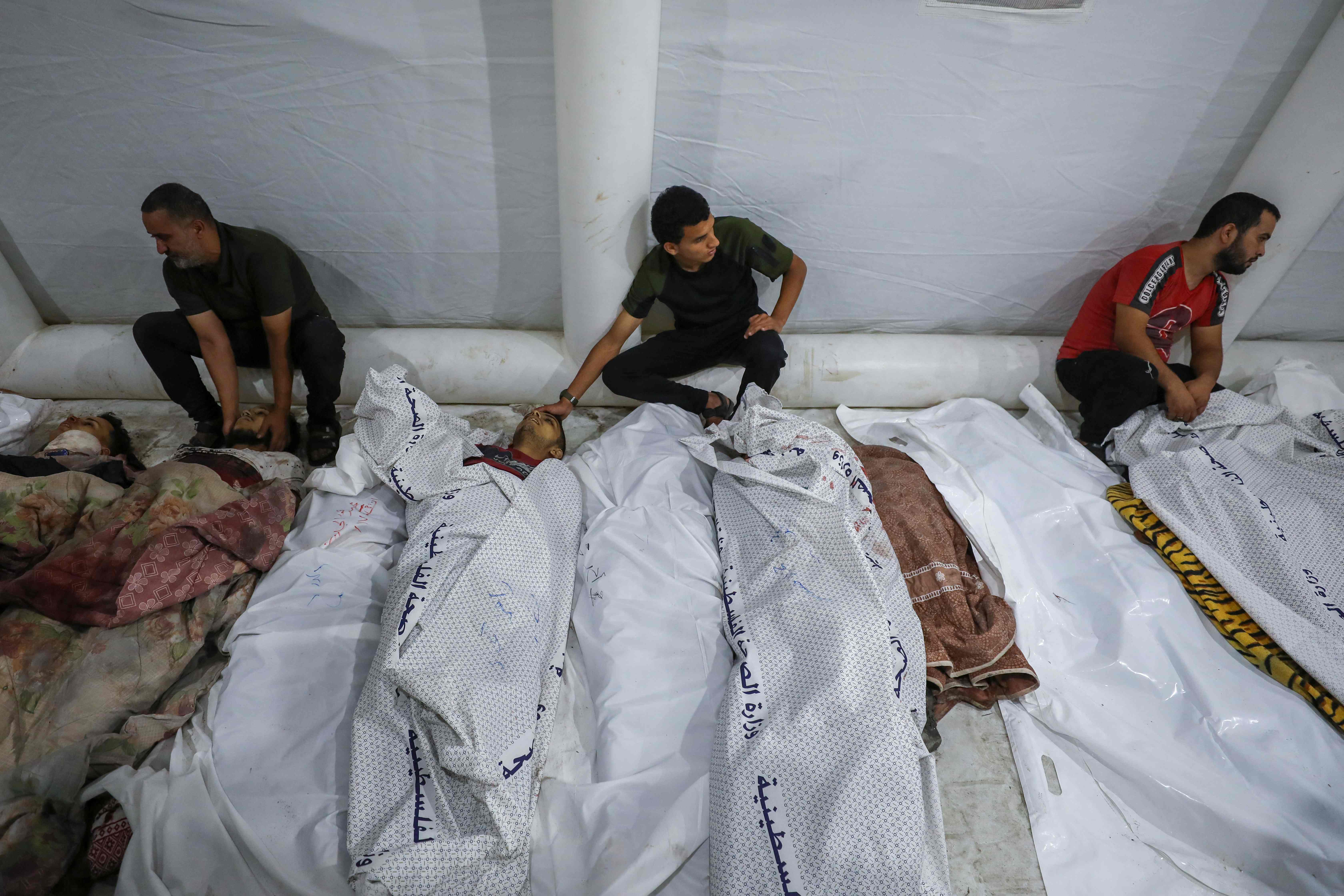 Warga Palestina menunggui jenazah kerabat mereka yang tewas dalam serangan udara Israel ke sebuah rumah sakit di Jalur Gaza.