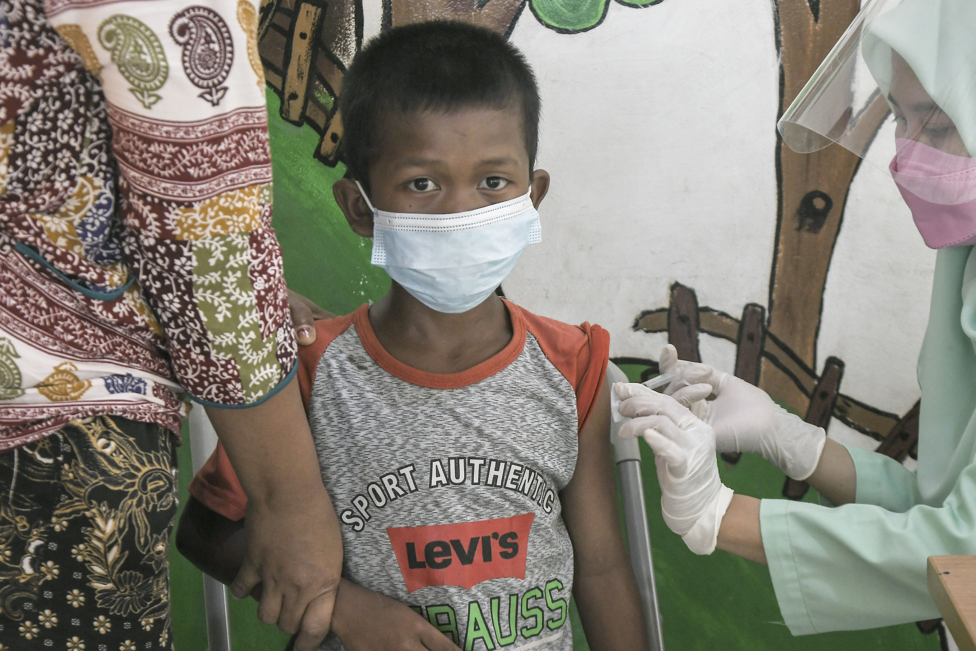 Petugas Puskemas (kanan) menyuntikkan vaksin Difteri Tetanus (DT) kepada anak di RPTRA Citra Permata, Rawa Bunga, Jatinegara, Jakarta.