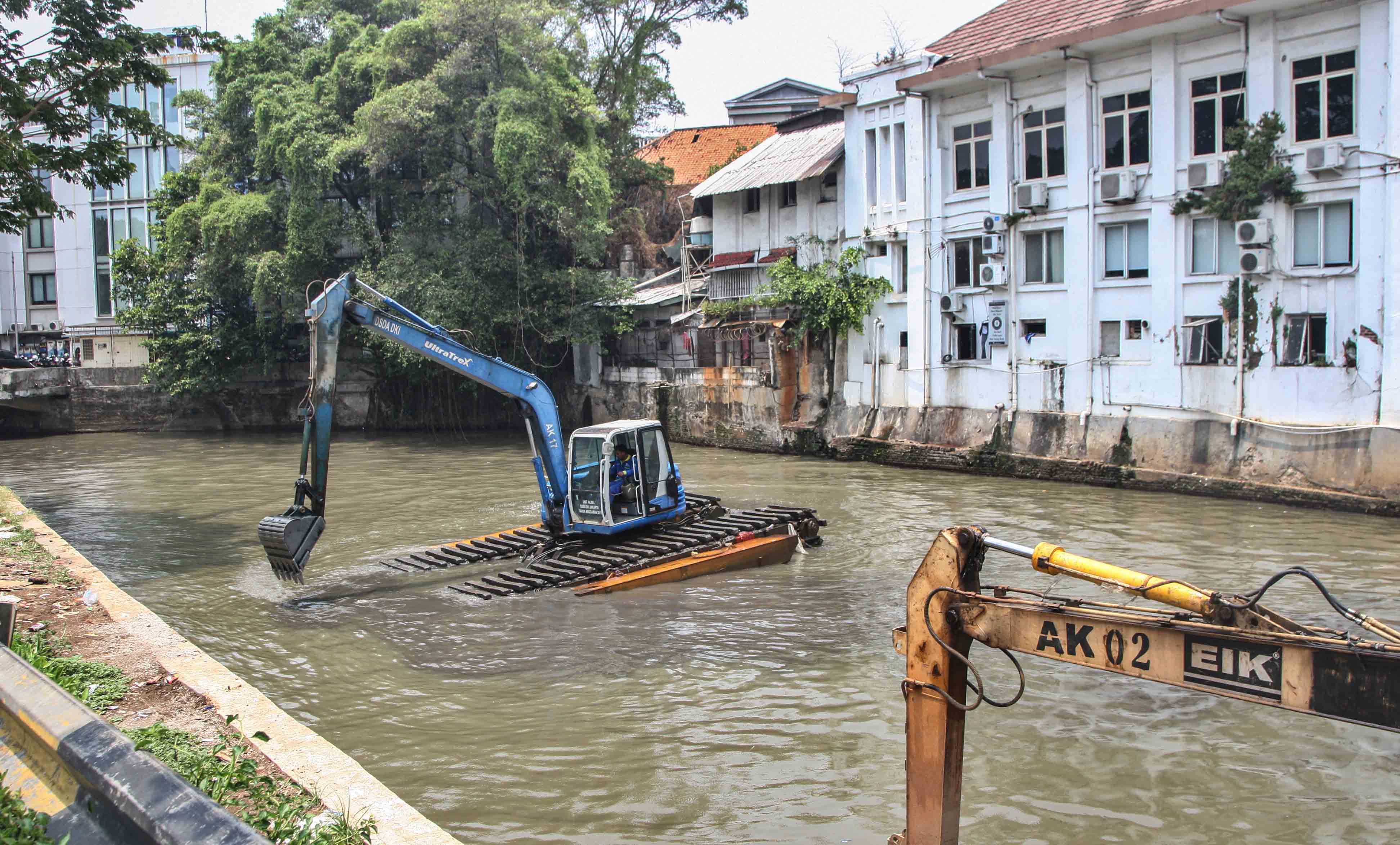 Petugas menggunakan ekskavator mengeruk endapan lumpur di Sungai Pasar Baru, Jakarta, Kamis (26/10/2023)