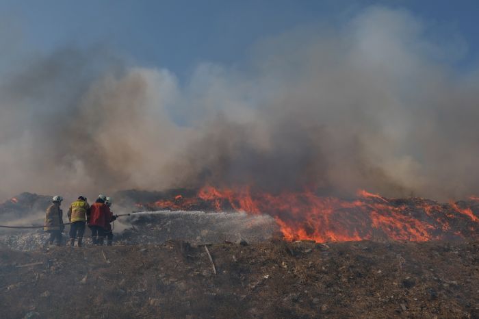 Petugas berupaya memadamkan api yang terus menjalar saat terjadi kebakaran sampah di TPA Suwung, Denpasar, Bali, Kamis (12/10). 