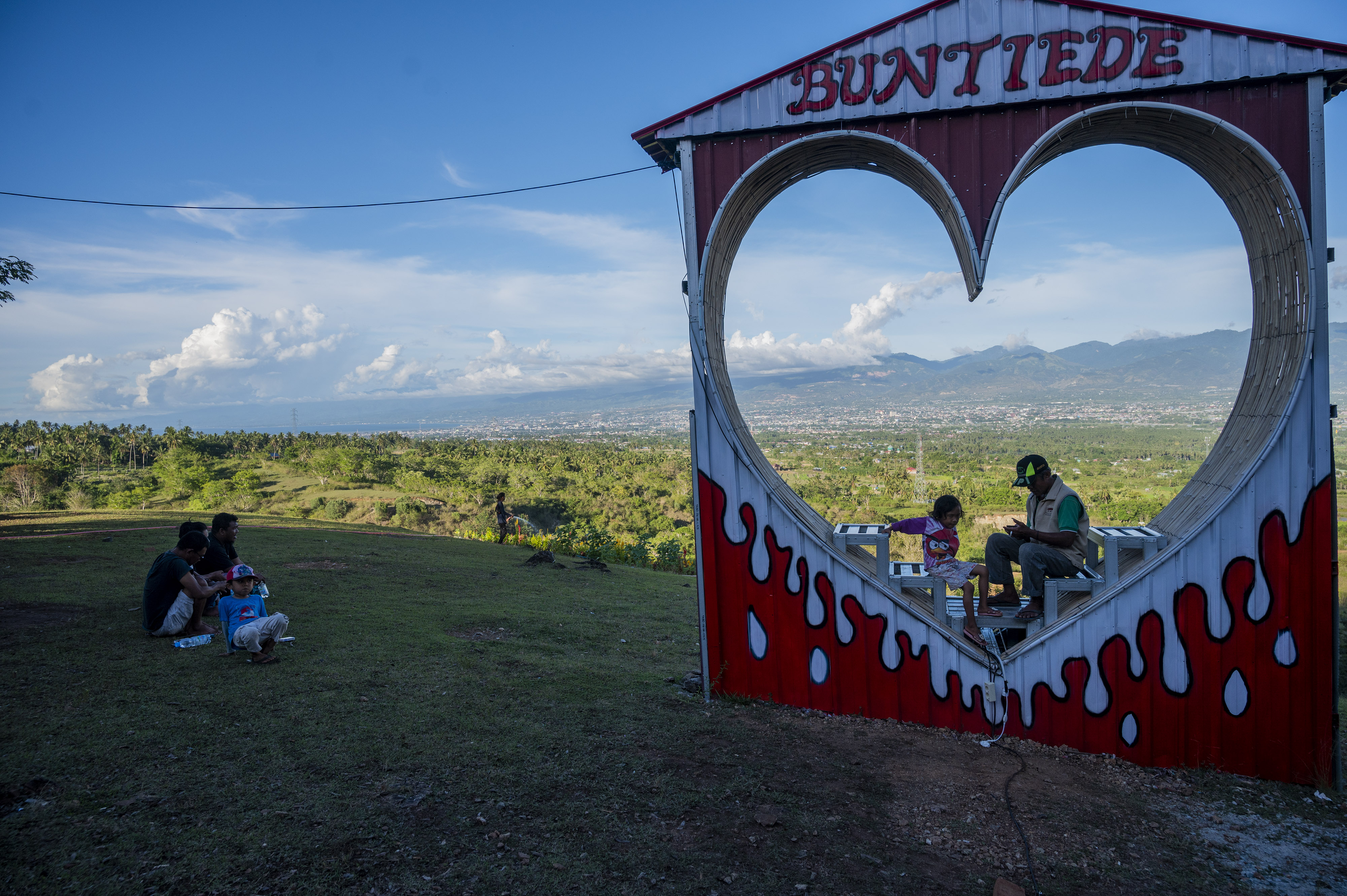 Sejumlah pengunjung menikmati pemandangan di kawasan wisata alam perbukitan Buntiede, Desa Padende, Sigi, Sulawesi Tengah, Rabu (5/1/2022).