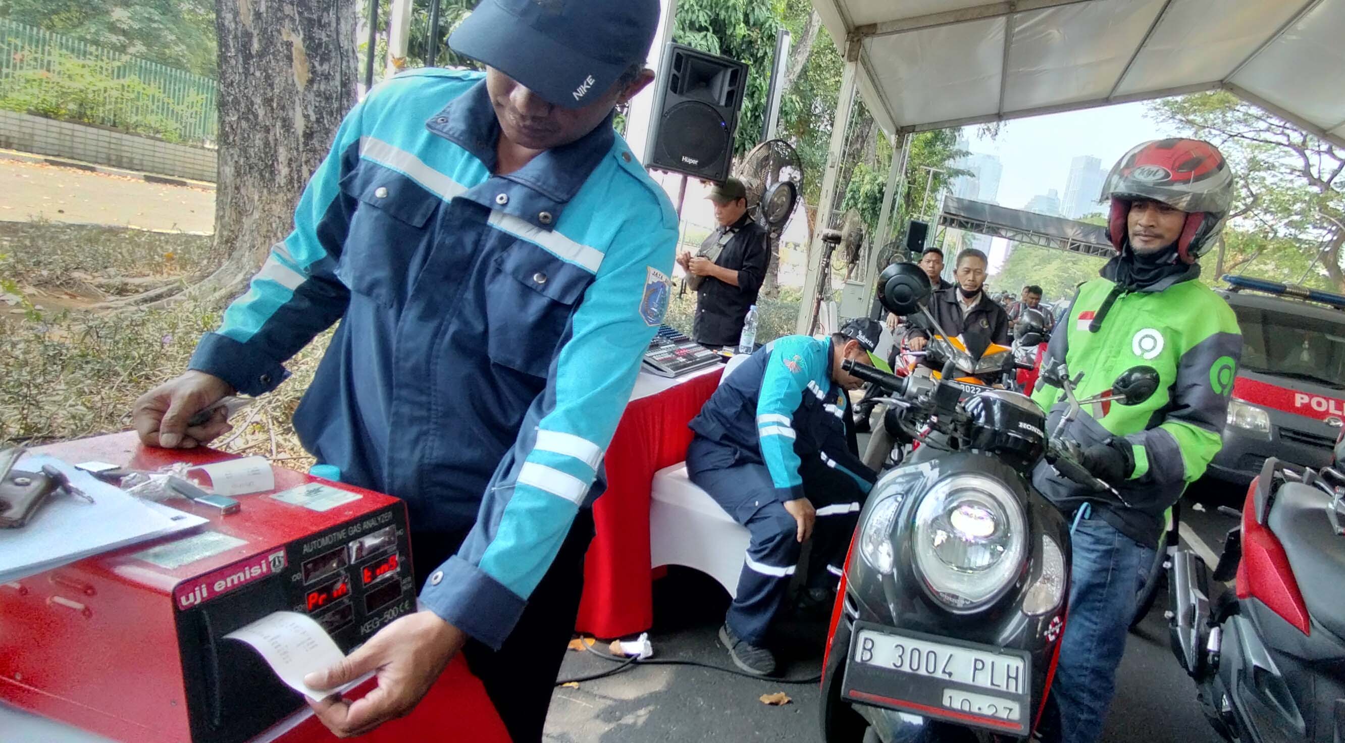 Petugas Uji Emisi mwlakukan pengecekan terhadap kendaraan bermotor yang melakukan uji emisi di Parkir Apec Gelora Bung Karno, Jakarta Pusat.