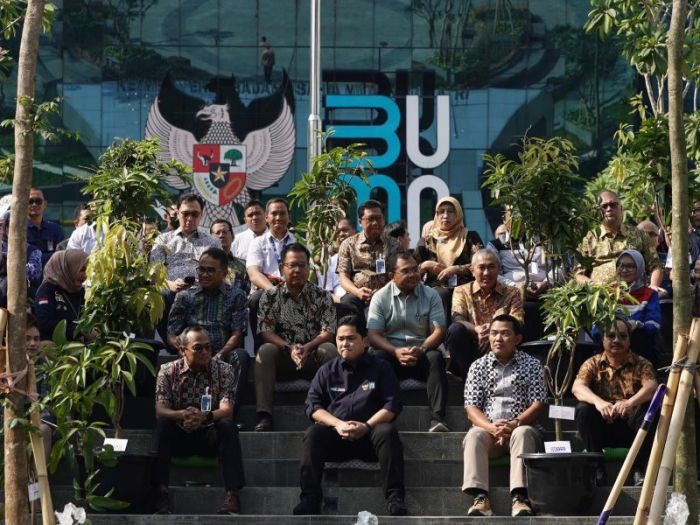 Erick Thohir duduk di area Kementerian BUMN yang baru saja ditanami pohon
