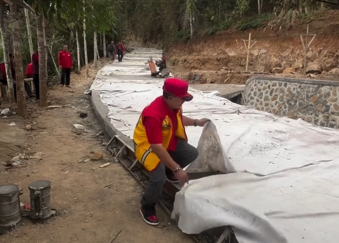 Bupati Cianjur Herman Suherman saat mengawasi pembangunan jalan beton