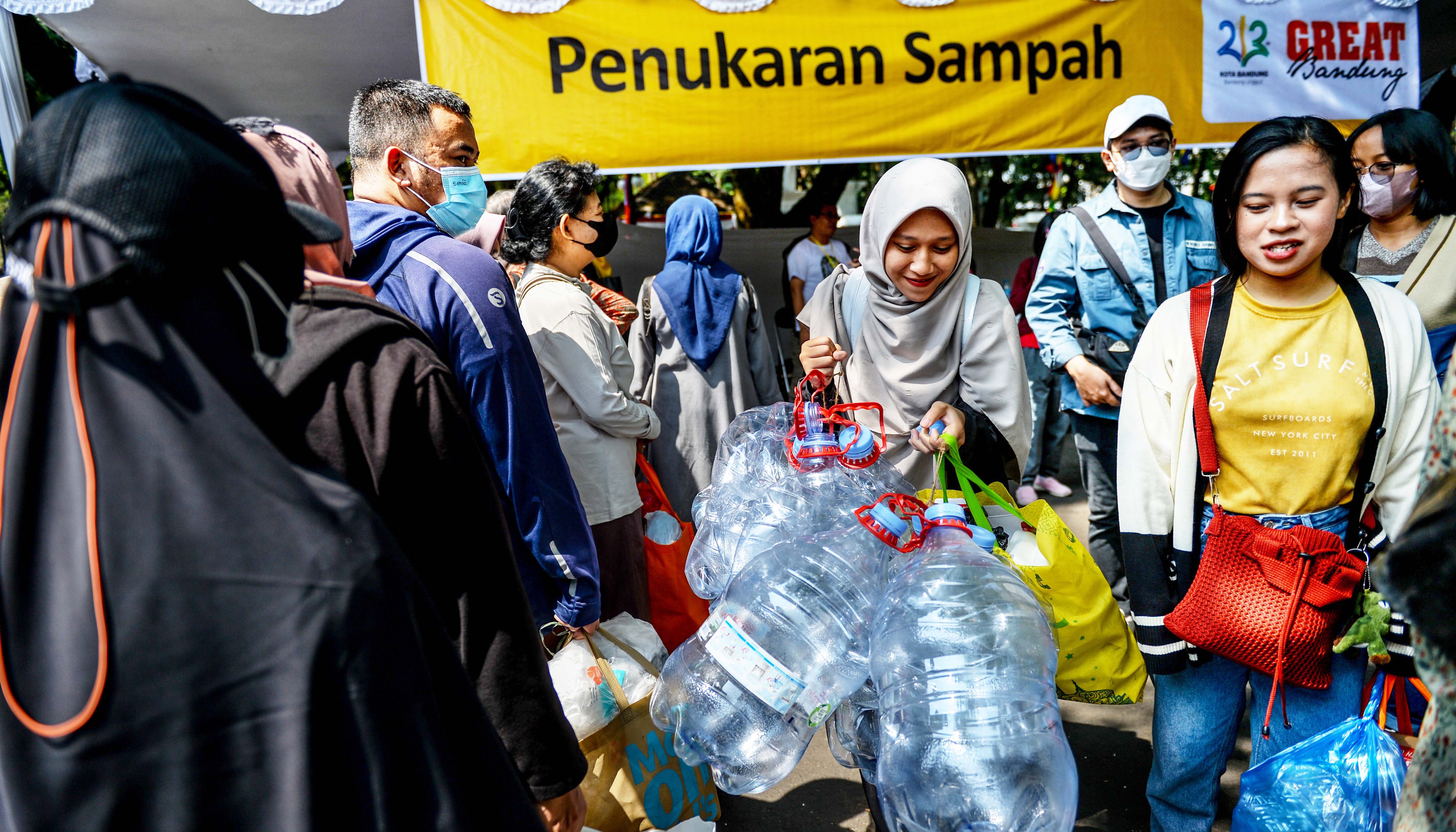 Warga menukar sampah dengan kupon untuk dapat dibelanjakan pada bazaar bayar pakai sampah di Balai Kota Bandung, Jawa Barat, Sabtu (23/9).