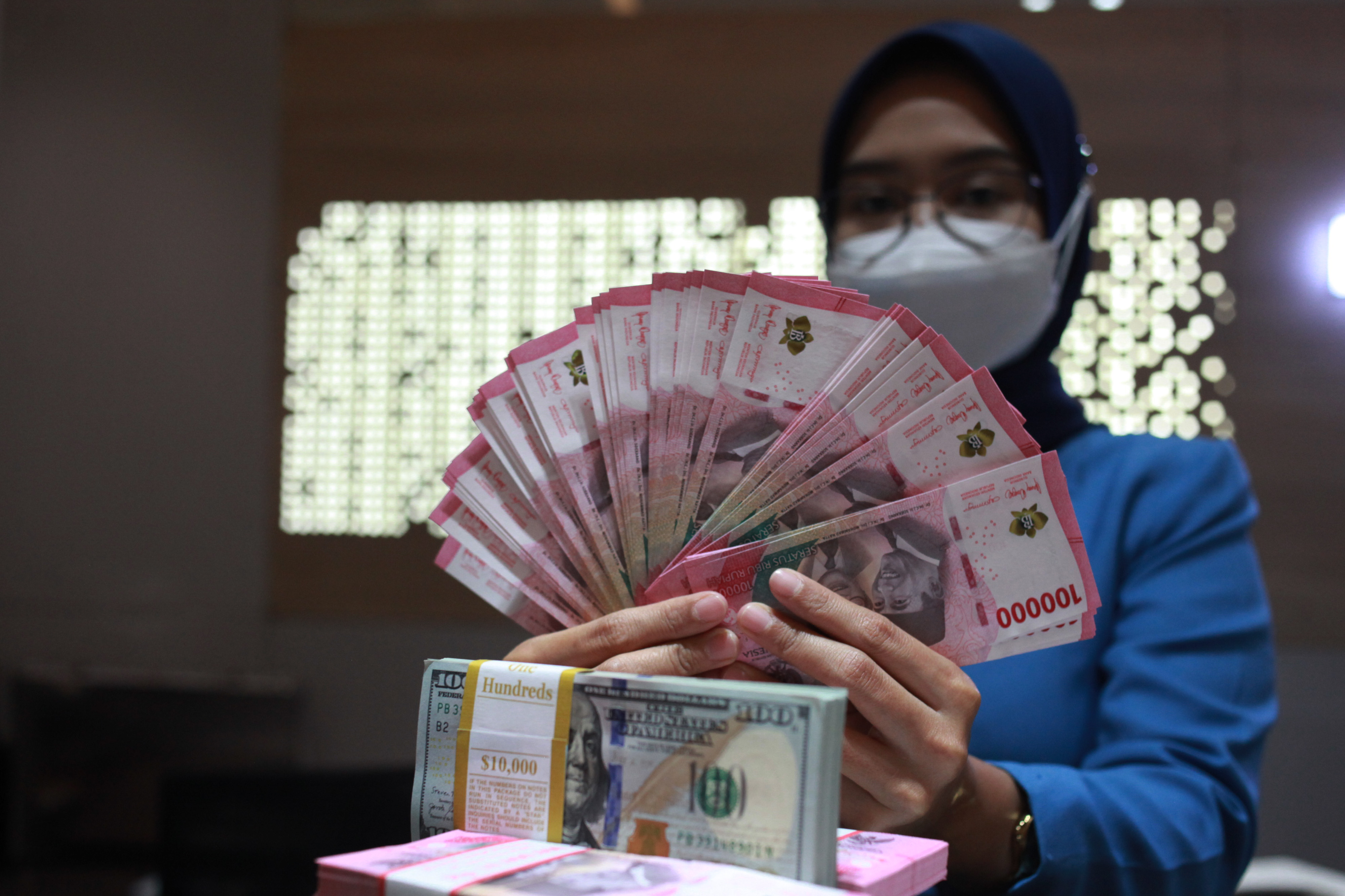 Petugas menunjukkan uang dolar AS dan uang rupiah di salah satu kantor cabang sebuah bank Jakarta, Selasa (31/1)