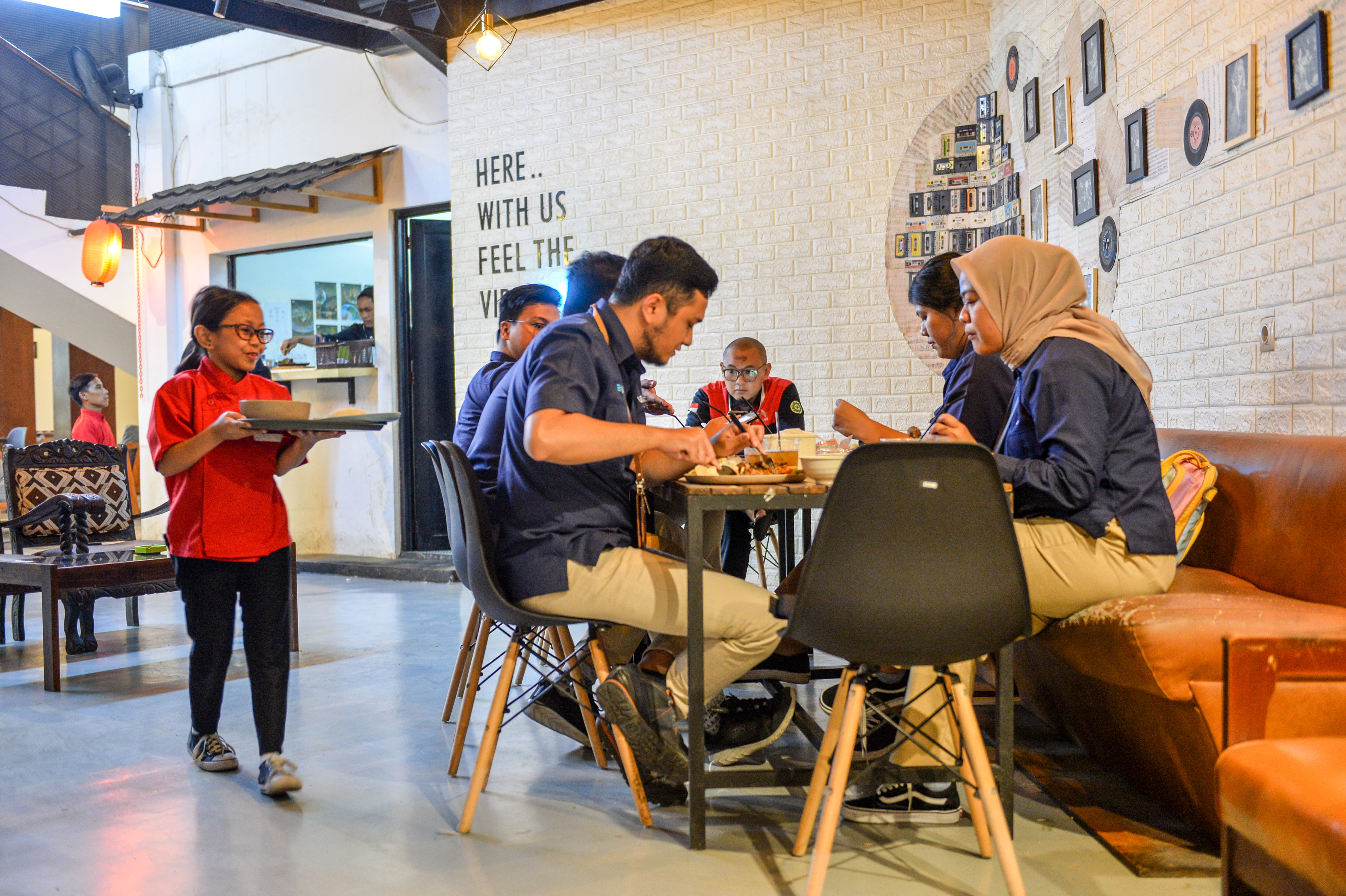 Pramusaji disabilitas membawa hidangan untuk diberikan kepada pelanggan di Restoran Iga Bakar Si Cebol, Bandung, Jawa Barat, Selasa (17/10).