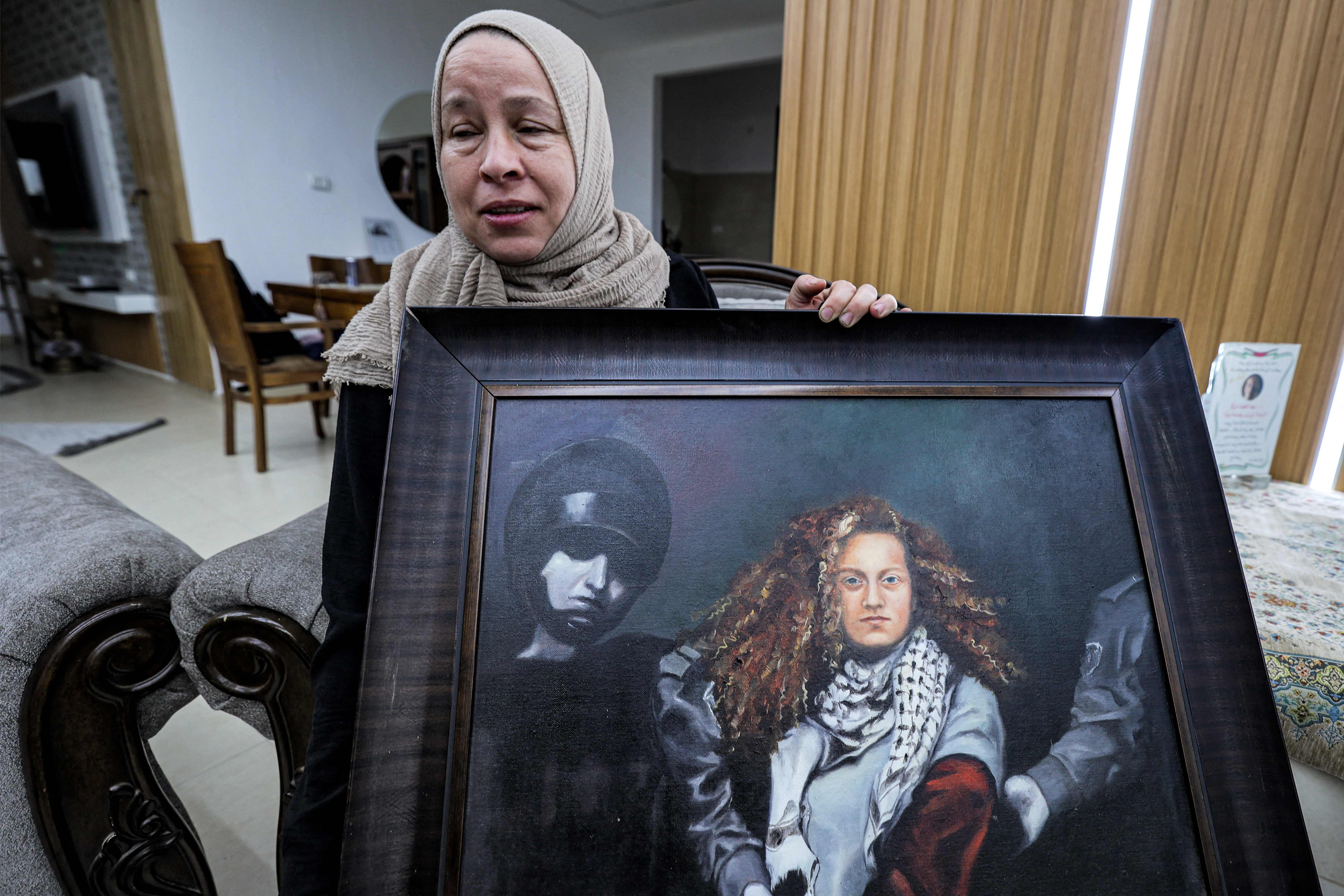 Nariman Tamimi menunjukkan foto anaknya, aktivis Palestina Ahed Tamimi, yang ditahan Israel baru-baru ini di Tepi Barat. 