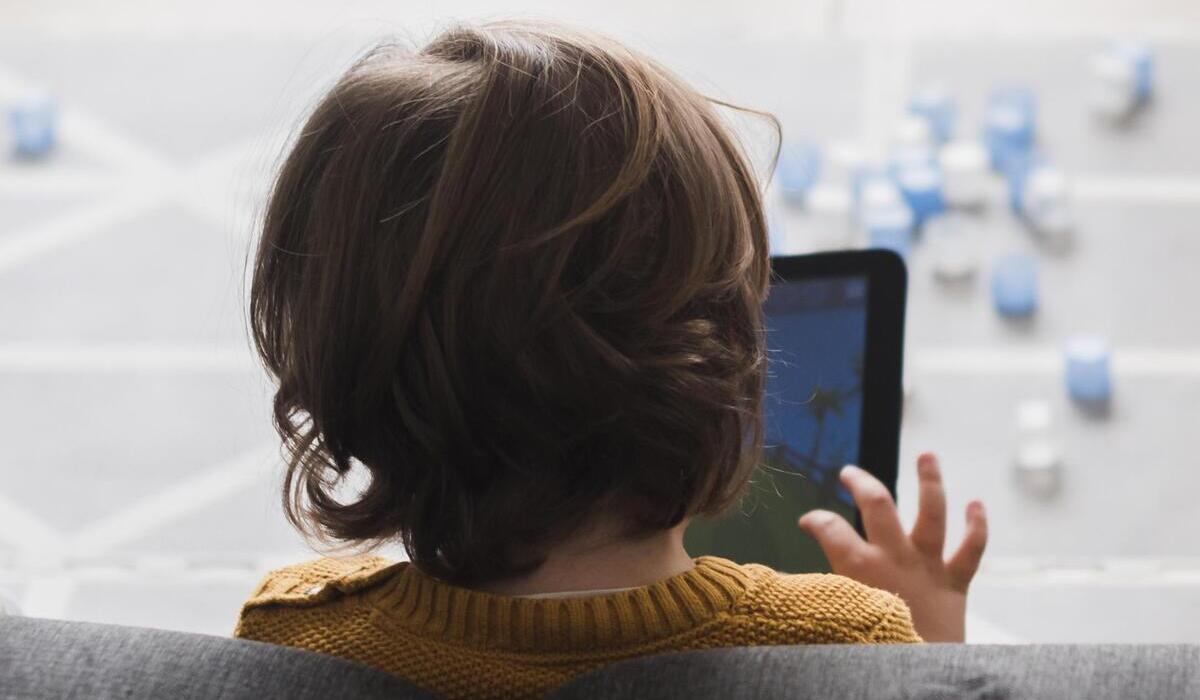 Ilustrasi seorang anak menggunakan gawai.