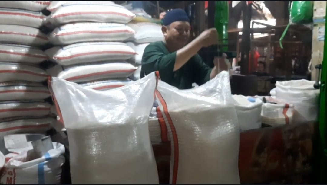 Pedagang beras di pasar tradisional Purwakarta tengah melayani pembeli