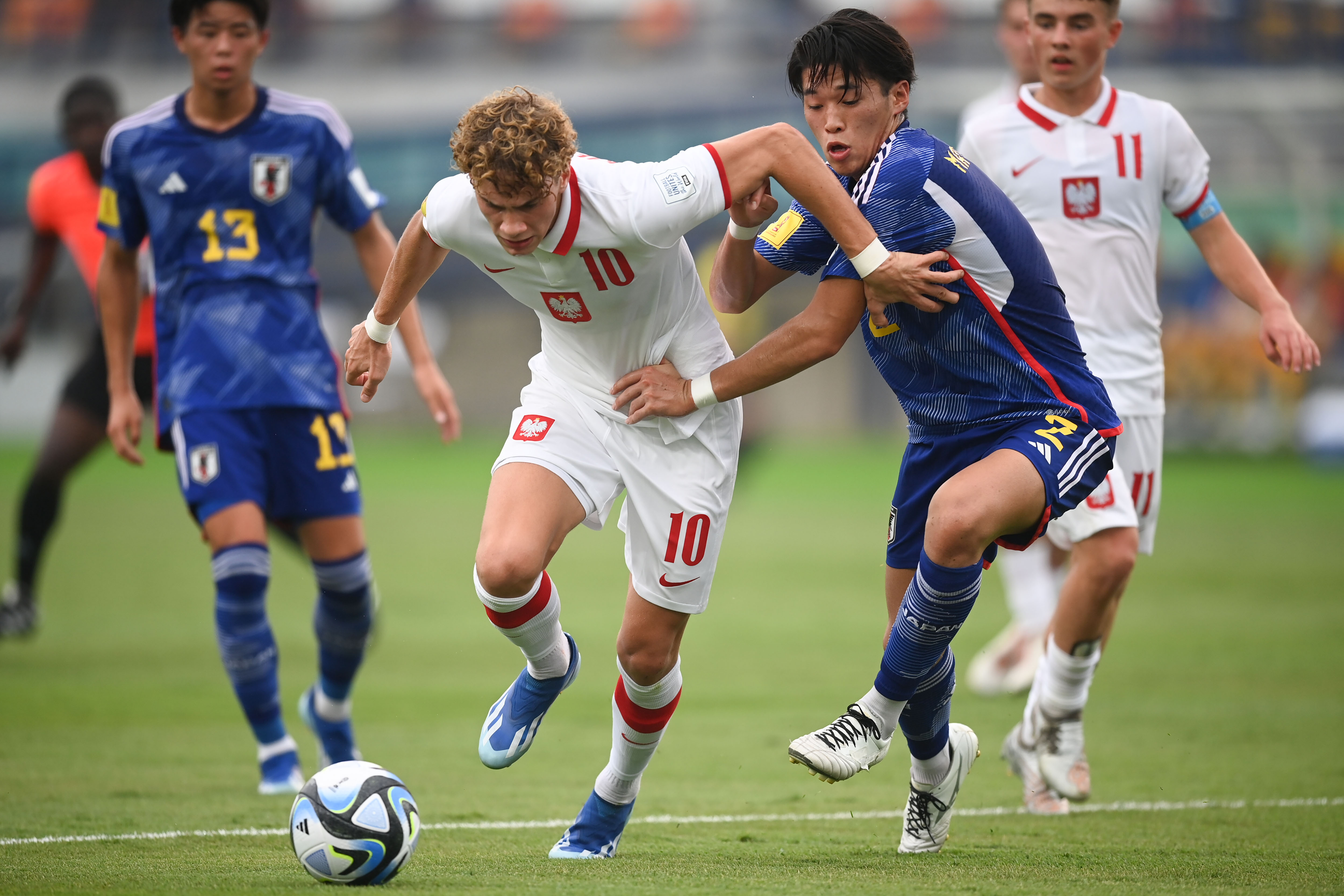 Pemain timnas Polandia Daniel Mikolajewski (kedua kiri) berusaha melewati hadangan pemain timnas Jepang Haruto Matsumoto (kedua kanan).