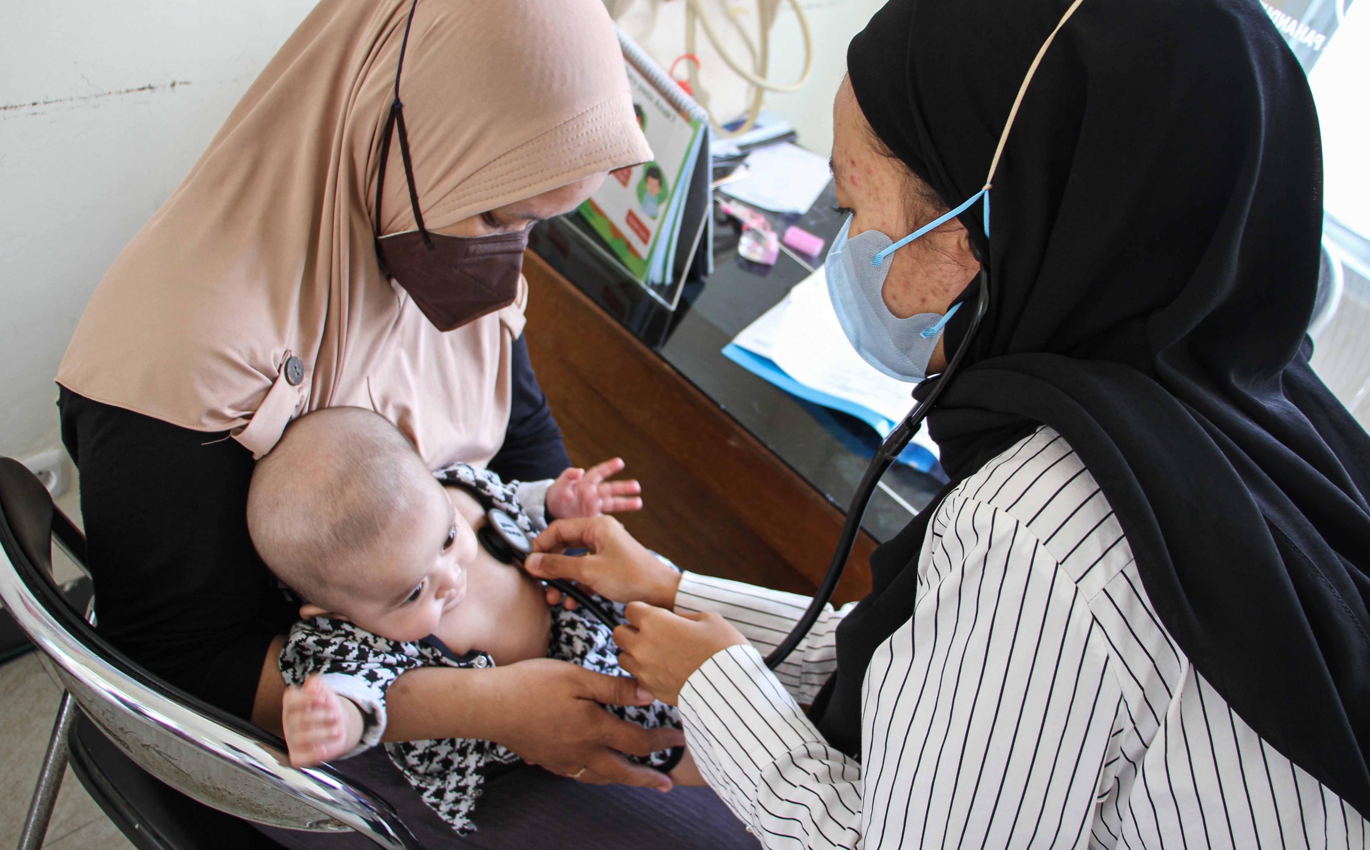 Seorang dokter tengah memeriksa kondisi kesehatan bayi