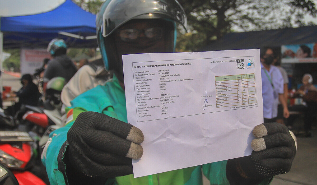 Pengendara memperlihatkan surat keterangan lolos uji emisi saat digelarnya tilang uji emisi di Jakarta, Rabu 1 November 2023.
