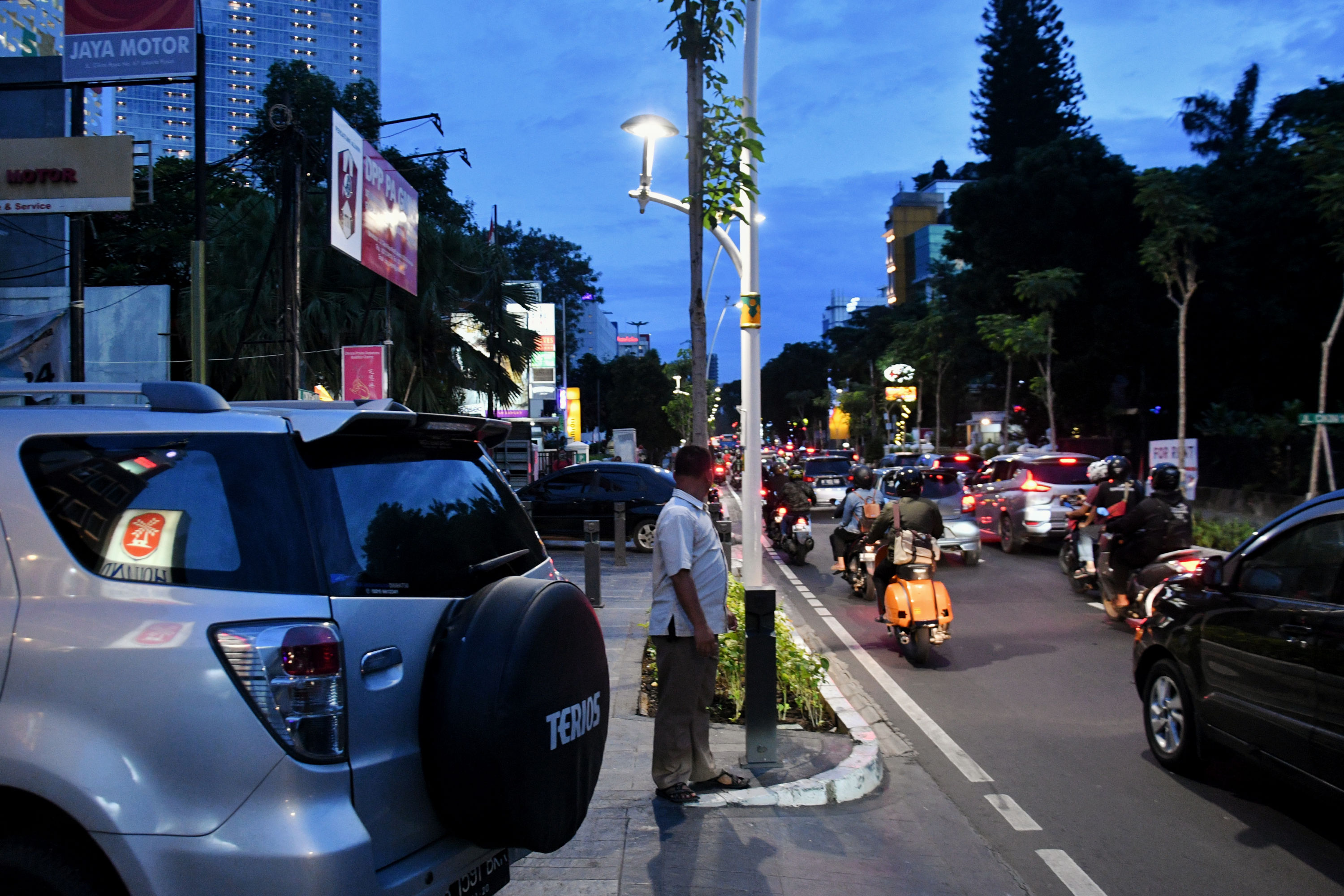 Pejalan kaki terpaksa harus keluar trotoar karena terhalangi sejumlah kendaraan yang parkir di trotoar kawasan Cikini