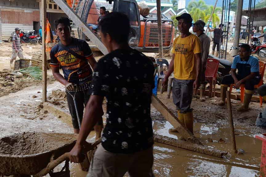 Warga di Kabupaten Aceh Selatan, Aceh, membersihkan lumpur dan sampah dari banjir bandang.