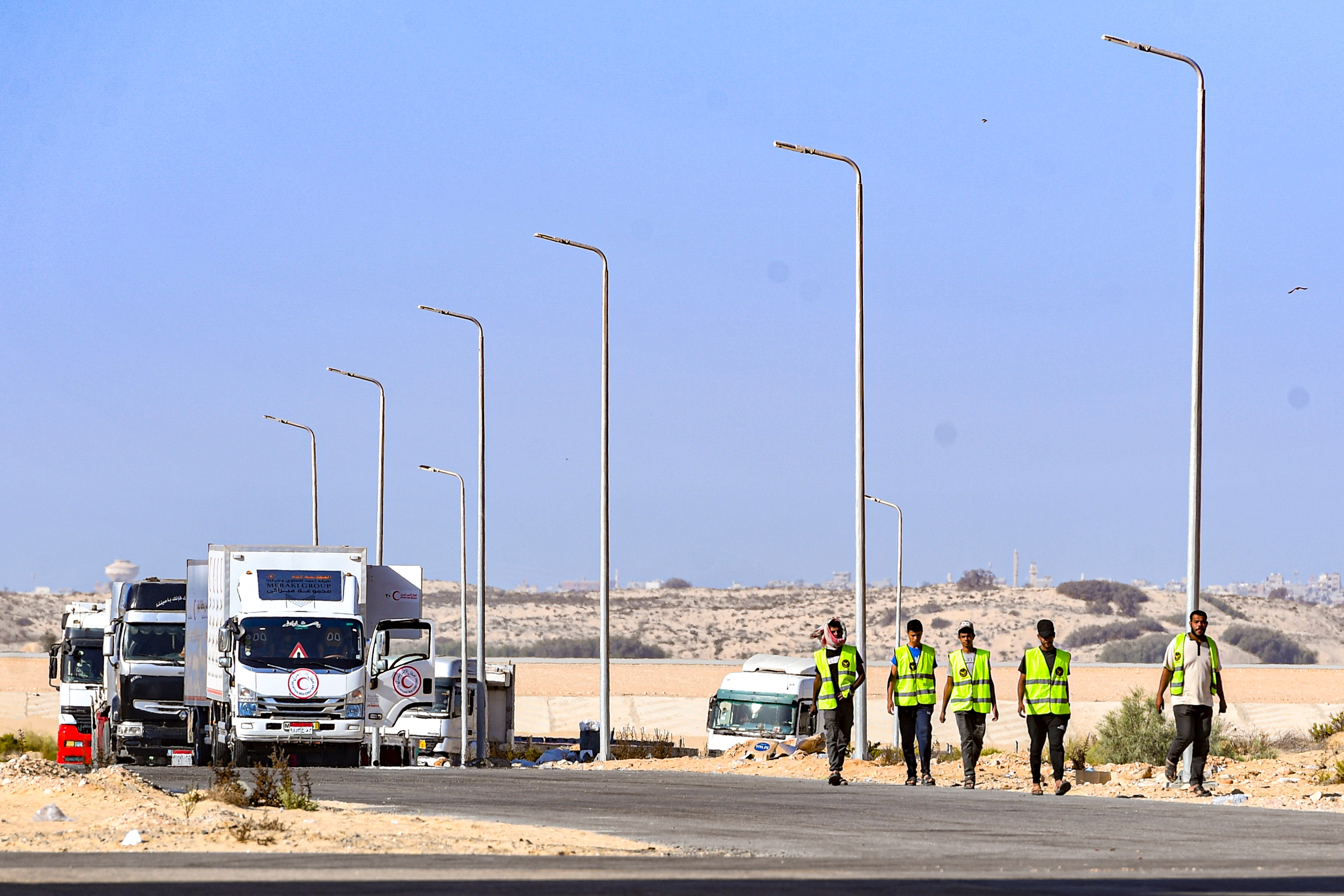 Sejumlah petugas Bulan Sabit Merah (MER-C) berjalan untuk mengangkut barang bantuan kemanusiaan yang akan diberikan untuk warga Palestina