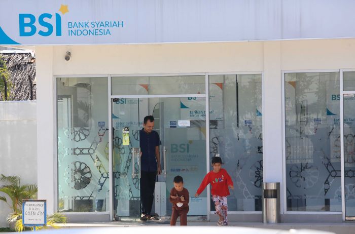 Nasabah keluar dari ruang anjungan tunai mandiri (ATM) Bank Syariah Indonesia (BSI) di Meulaboh, Aceh Barat, Aceh