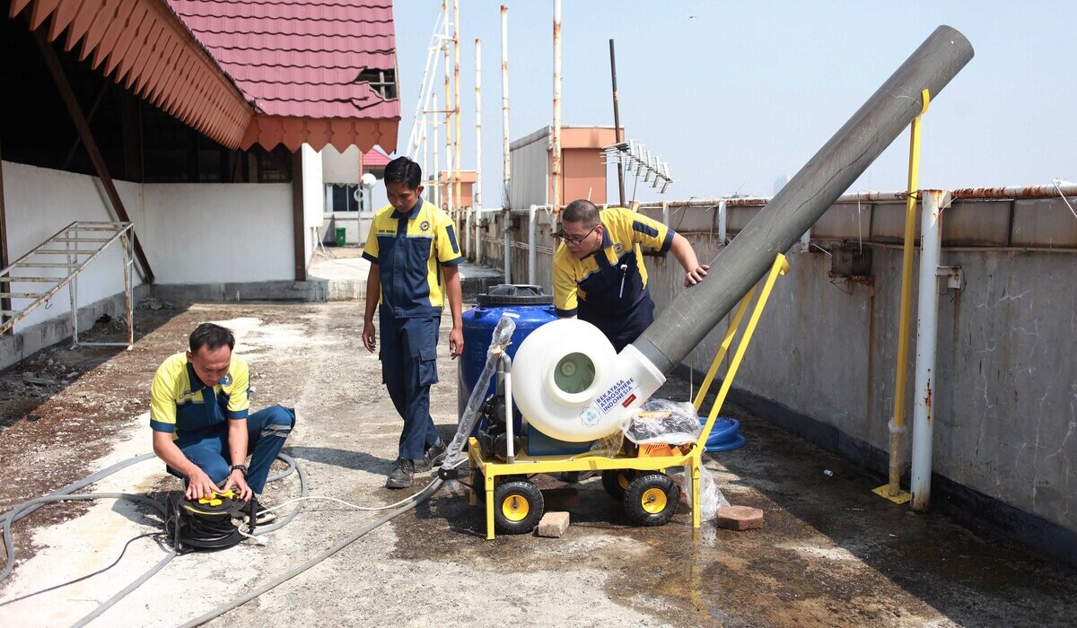 Pekerja menyemprotkan air menggunakan water mist generator di Kantor Walikota, Jakarta Pusat, Jakarta.