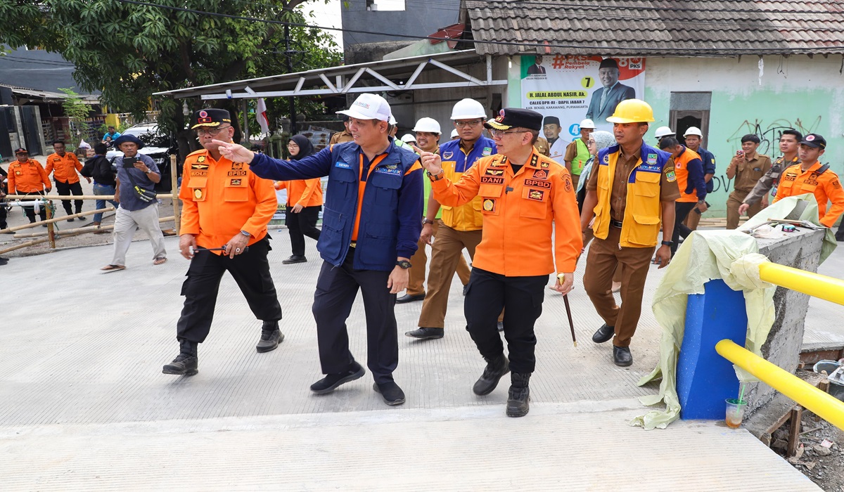 Pj Bupati Bekasi Dani Ramdan meninjau progres pengerjaan Jembatan Kali Sadang di Pasar Rengas, Kelurahan Wanasari.
