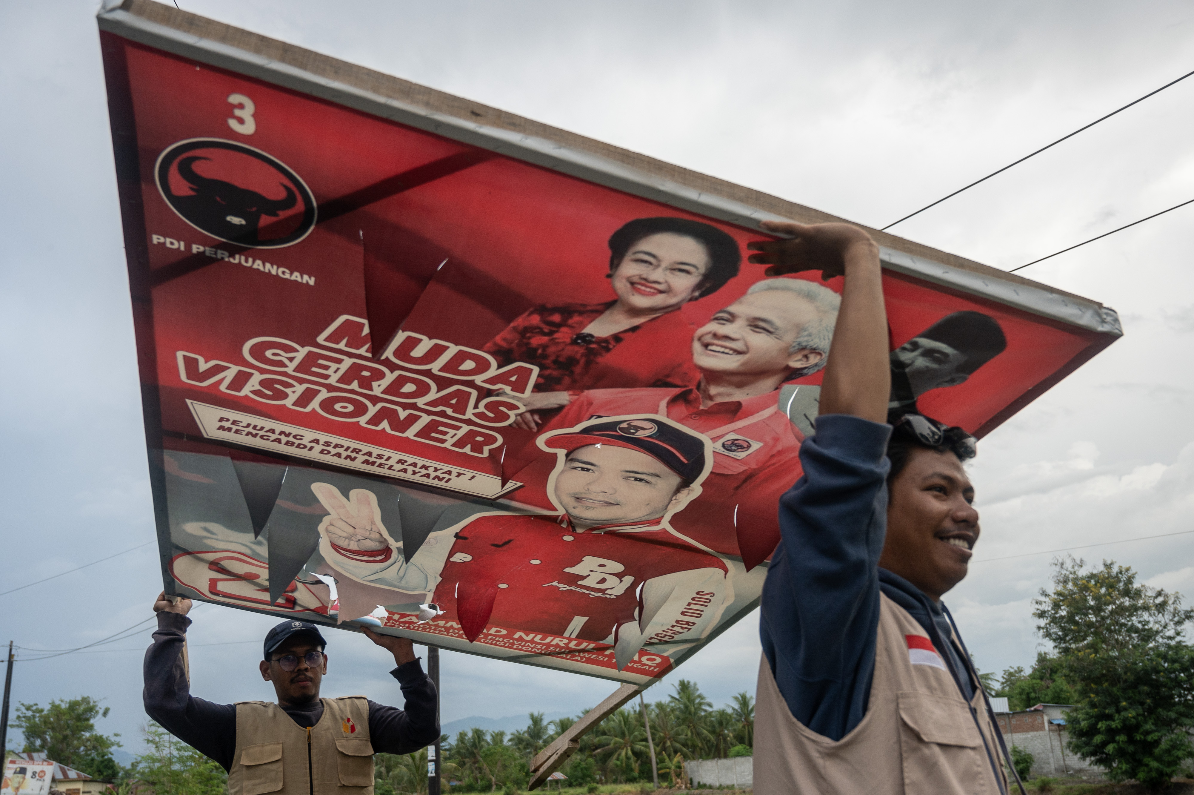 Petugas Bawaslu menertibkan alat peraga kampanye