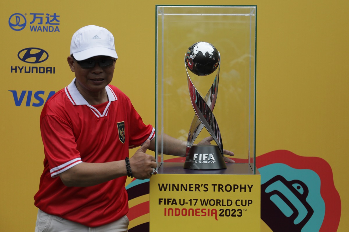 Warga berpose dengan trofi Piala Dunia U-17 di sela kegiatan Car Free Day (CFD) di kawasan Bundara HI Jakarta.