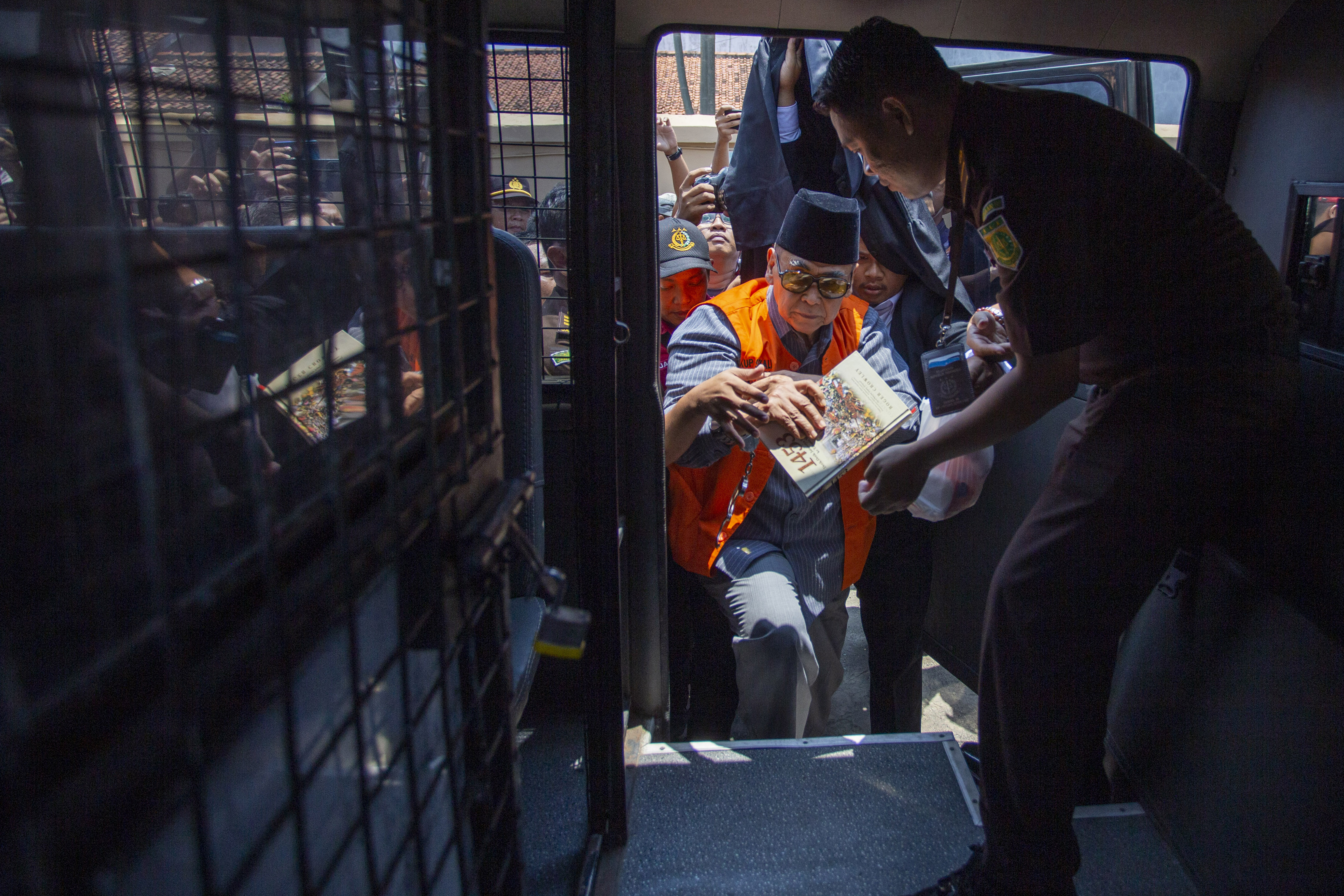 Pimpinan Pondok Pesantren Al-Zaytun Panji Gumilang memasuki mobil tahanan