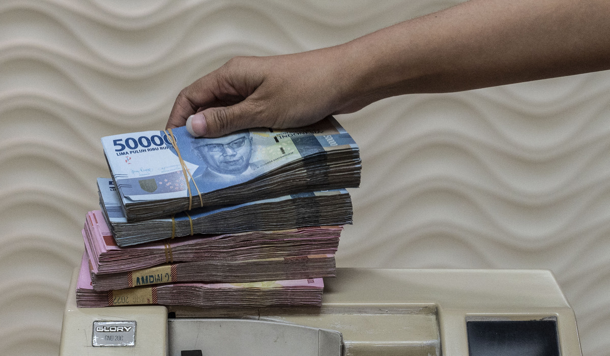 Pegawai menghitung uang Rupiah di salah satu tempat penukaran uang di Jakarta.