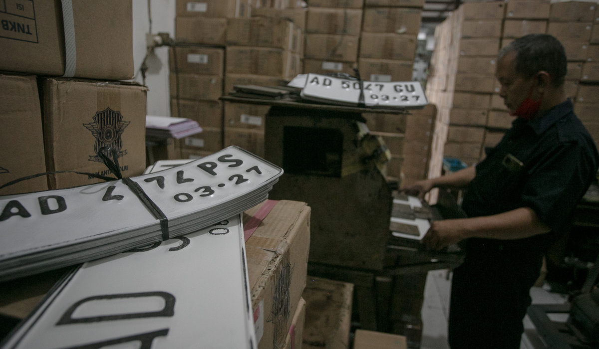 Petugas mencetak pelat nomor putih di kantor Samsat Solo, Jawa Tengah.