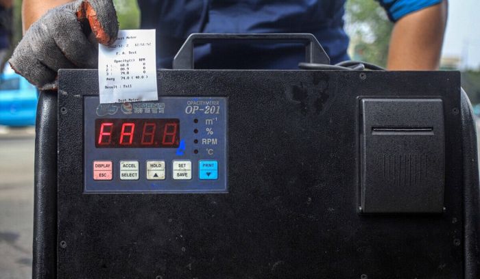 Petugas memperlihatkan surat keterangan hasil uji emisi saat digelarnya razia dan tilang uji emisi di Jakarta, Rabu, (1/11).