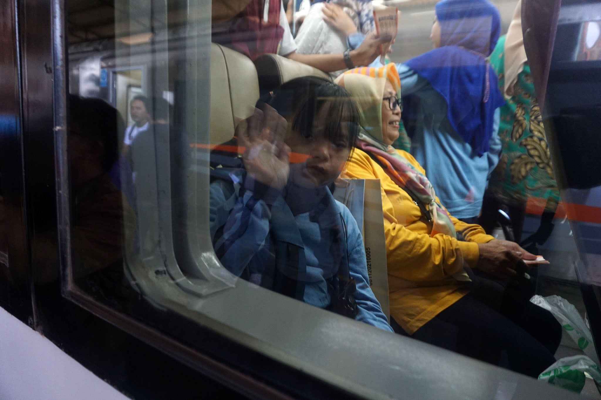 Seorang anak menikmati perjalanan dengan kereta api