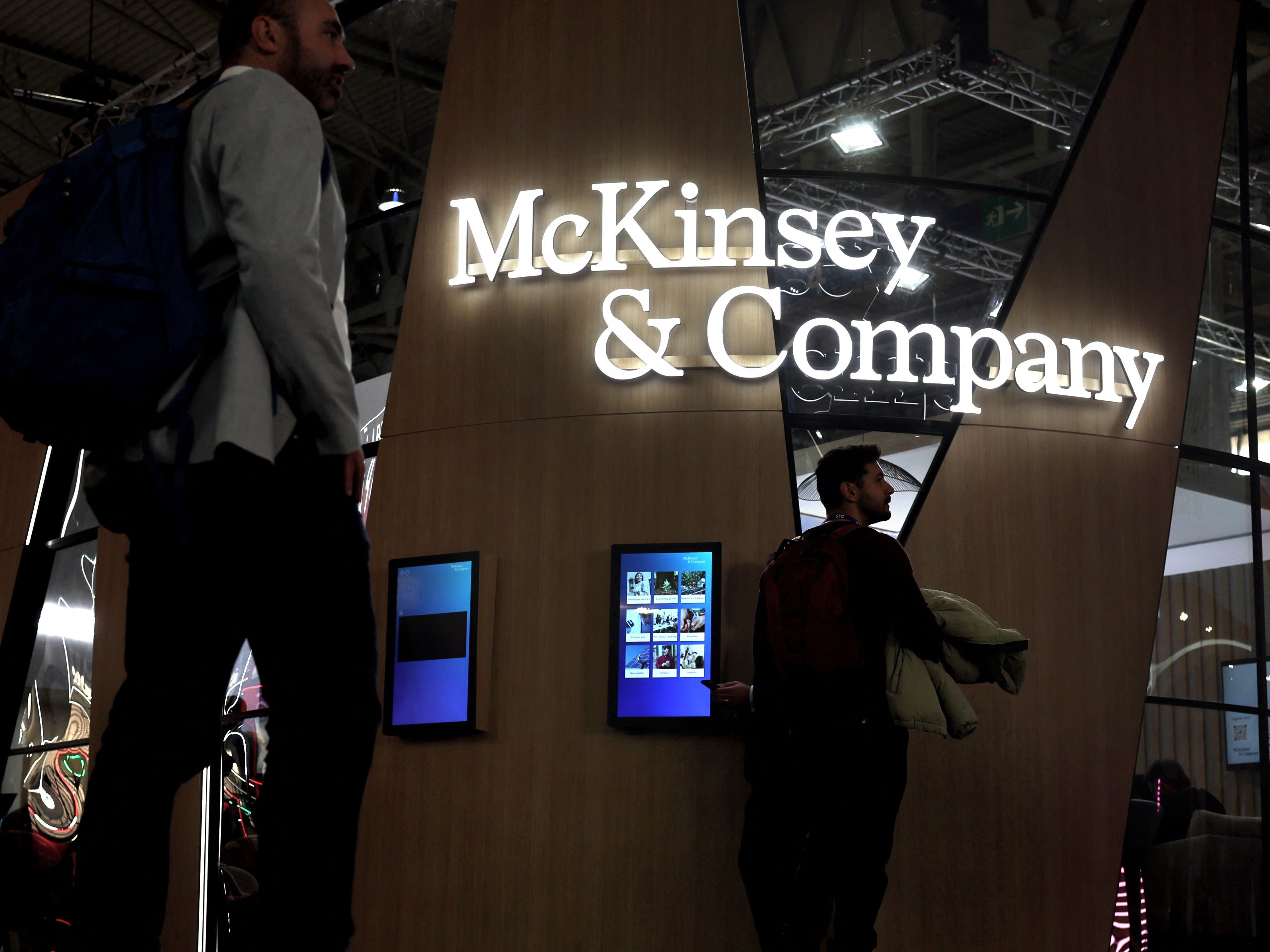 Pengunjung berjalan melewati perusahaan konsultan manajemen global AS, McKinsey & Company, di Mobile World Congress (MWC).