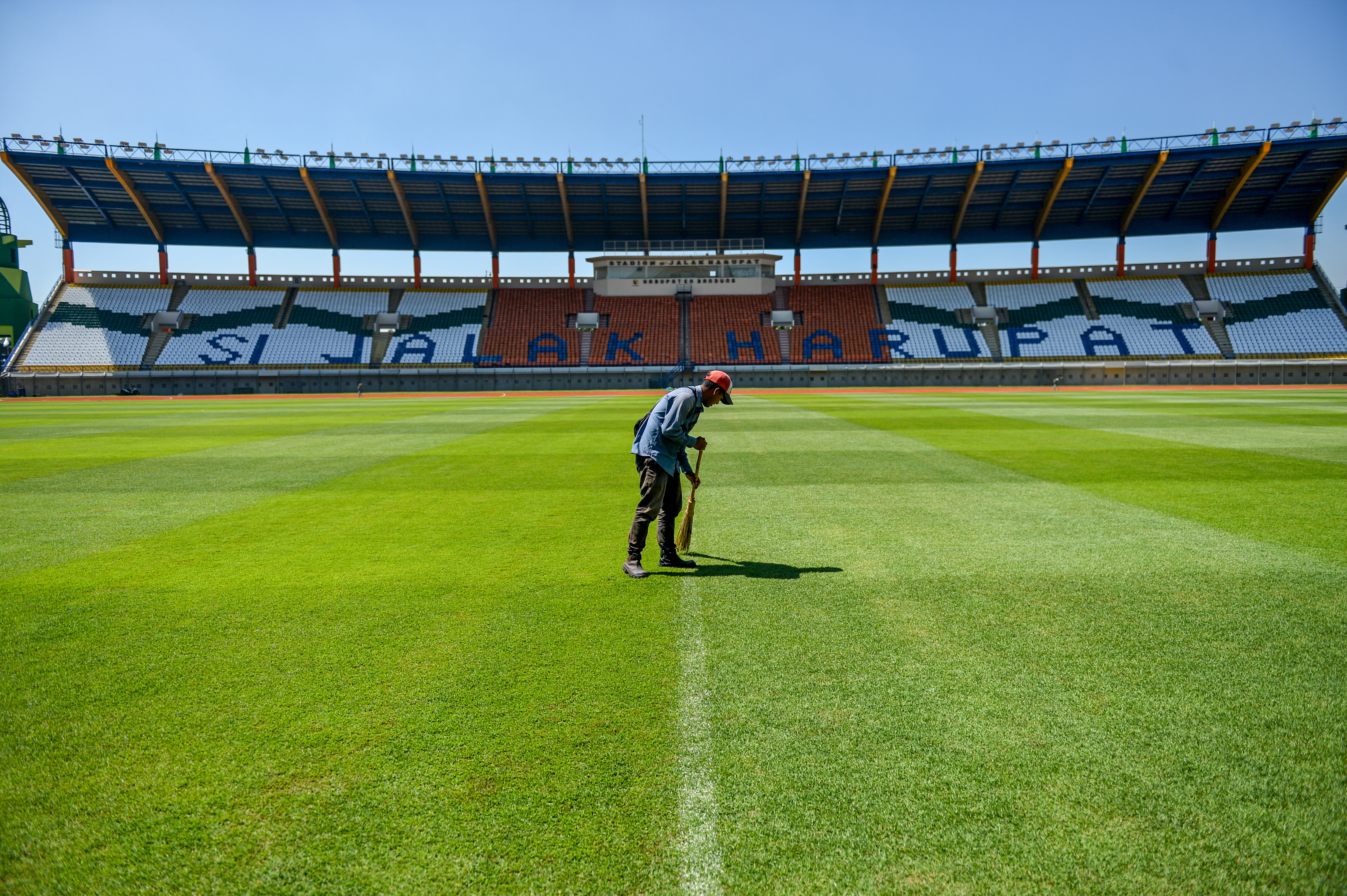 Seorang pekerja tengah melakukan perawatan di Stadion si Jalak Harupat, Kabupaten Bandung.