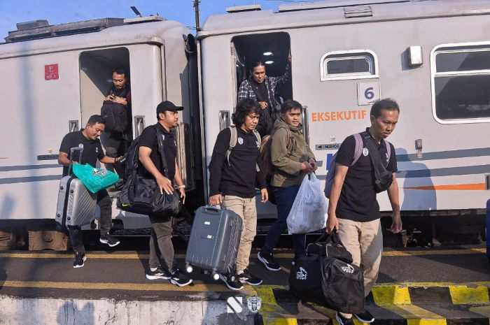 Para penumpang kereta api jarak jauh tiba di stasiun kedatangan