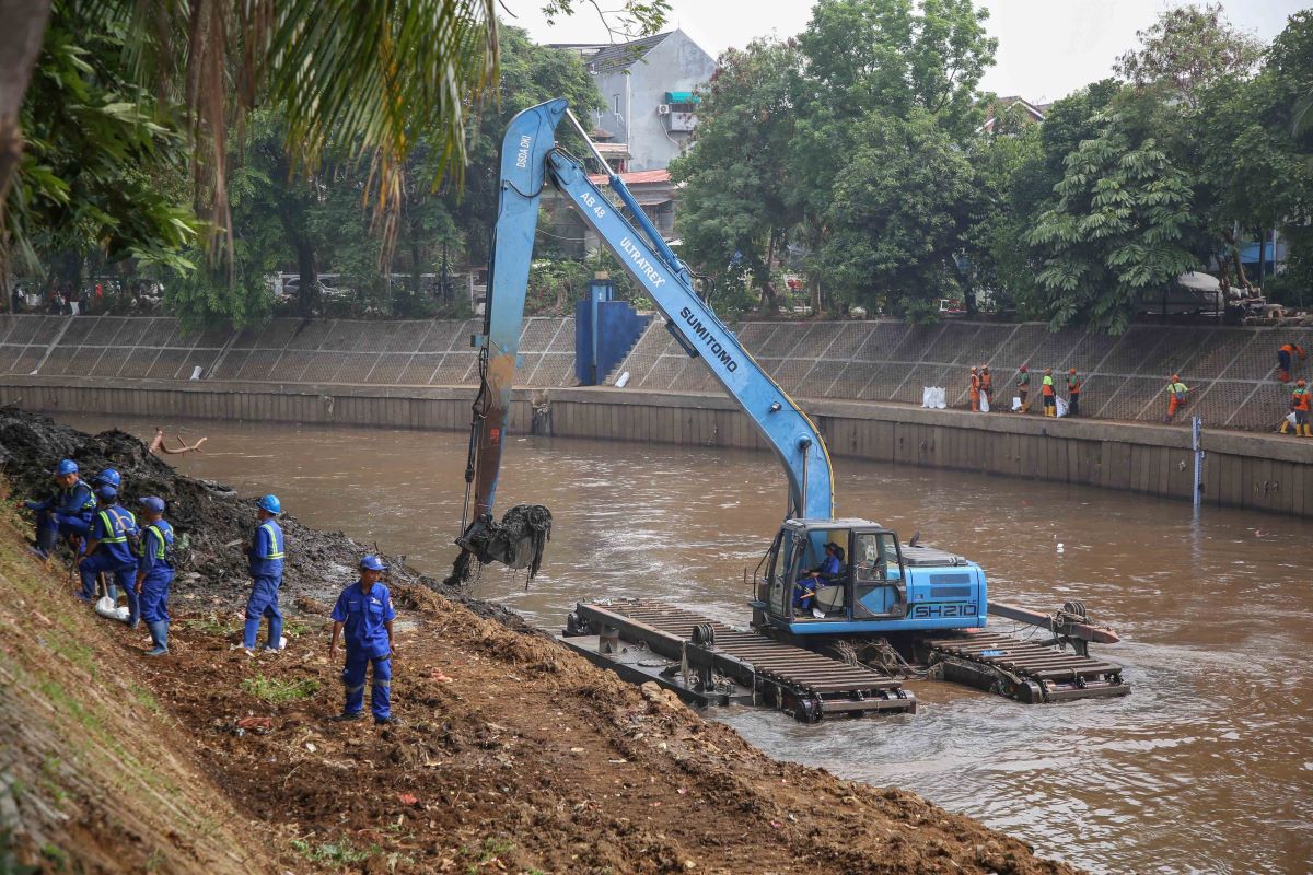 Petugas SDA DKI Jakarta dibantu alat berat melakukan pengerukan Sungai Ciliwung.