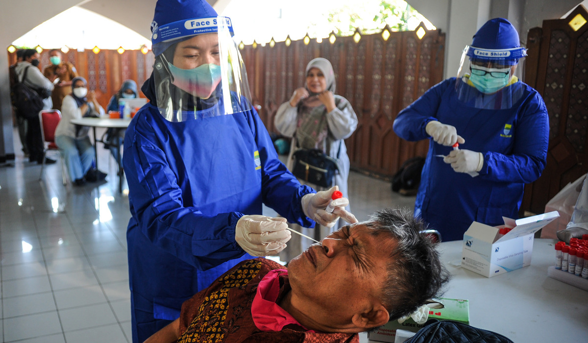 Ilustrasi petugas kesehatan mengambil sampel tes PCR.