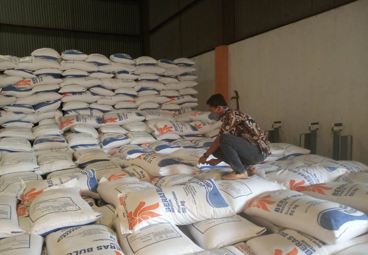 Petugas tengah membersihkan beras di Gudang Bulog Cirebon