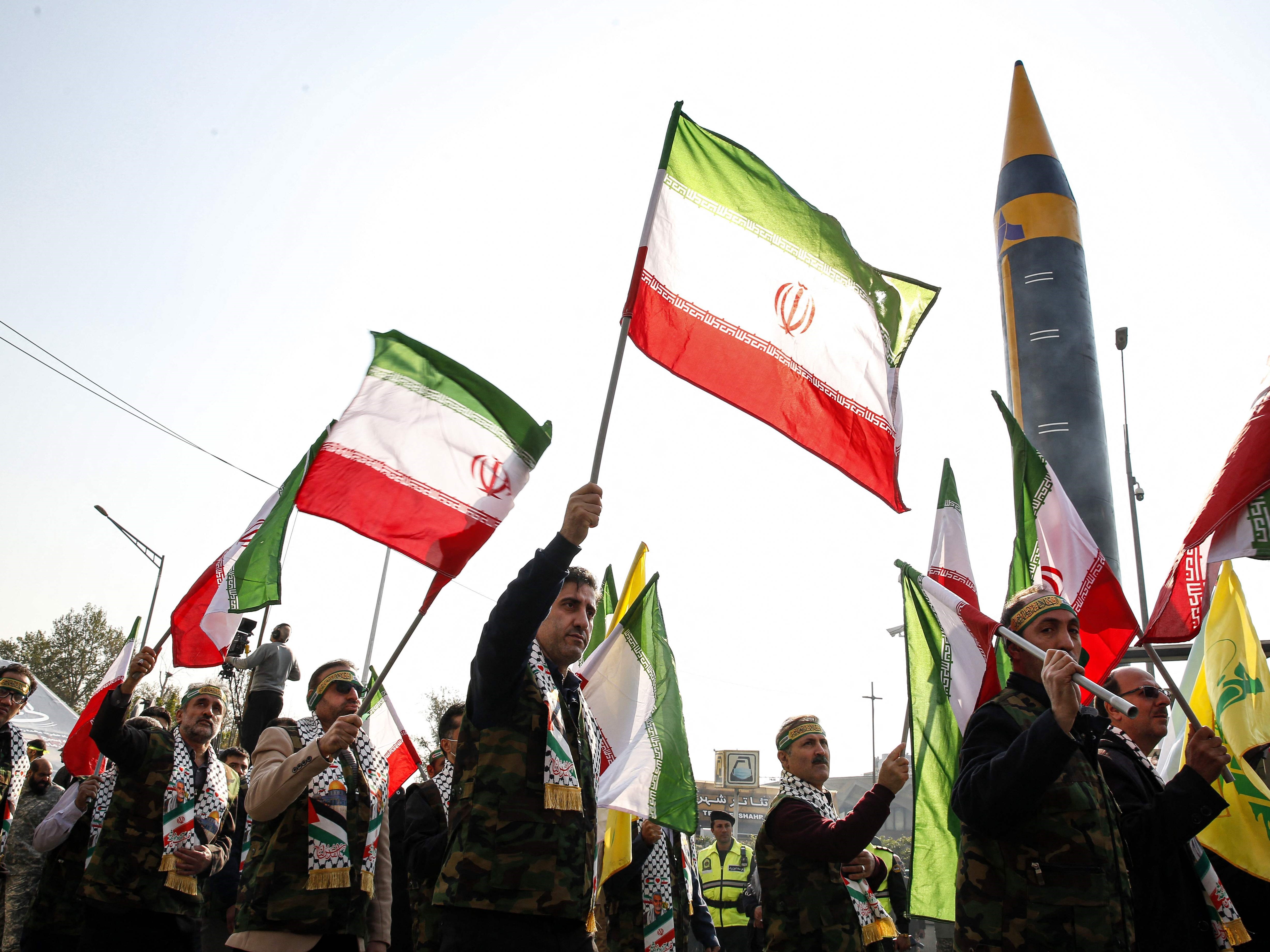 Anggota pasukan paramiliter Iran Basij berbaris di samping rudal balistik Khorramshahr generasi keempat.