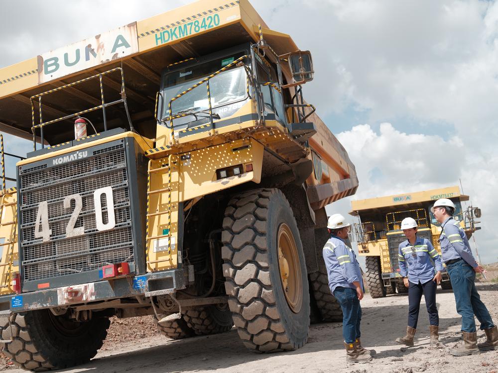 Tiga orang pegawai PT. Bukit Makmur Mandiri Utama (BUMA) sedang berada di salah satu situs tambang di Kalimantan. 