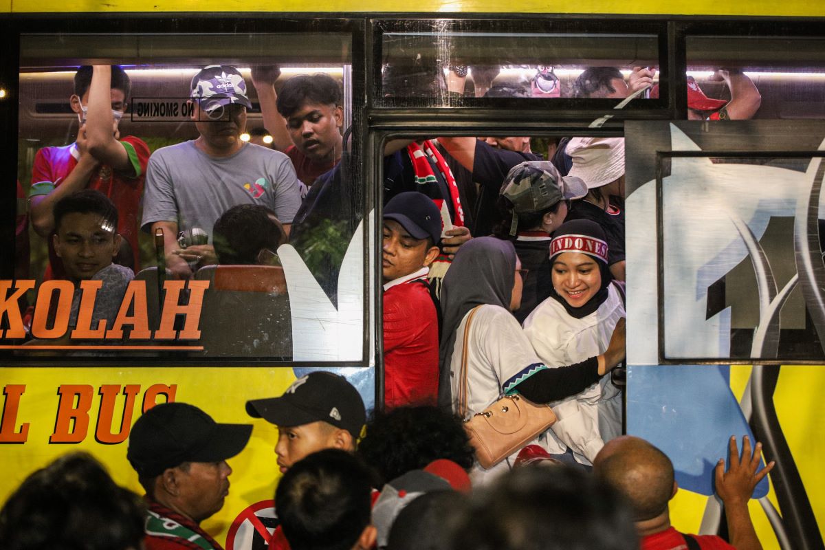 Para penonton Piala Dunia U-17 menaiki bus shuttle.