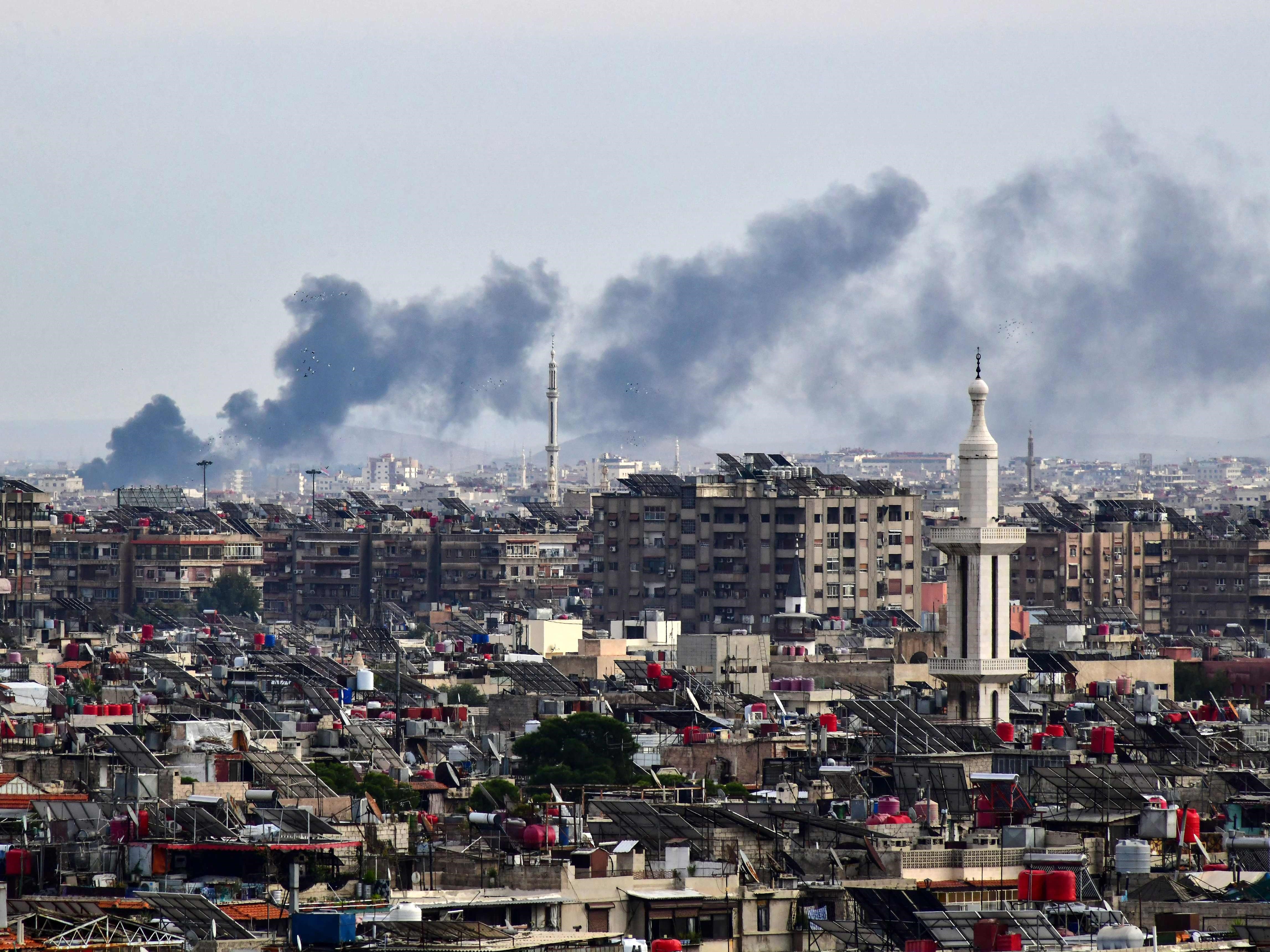 Asap mengepul di atas gedung-gedung setelah serangan Israel di pinggiran Damaskus pada 22 November 2023.