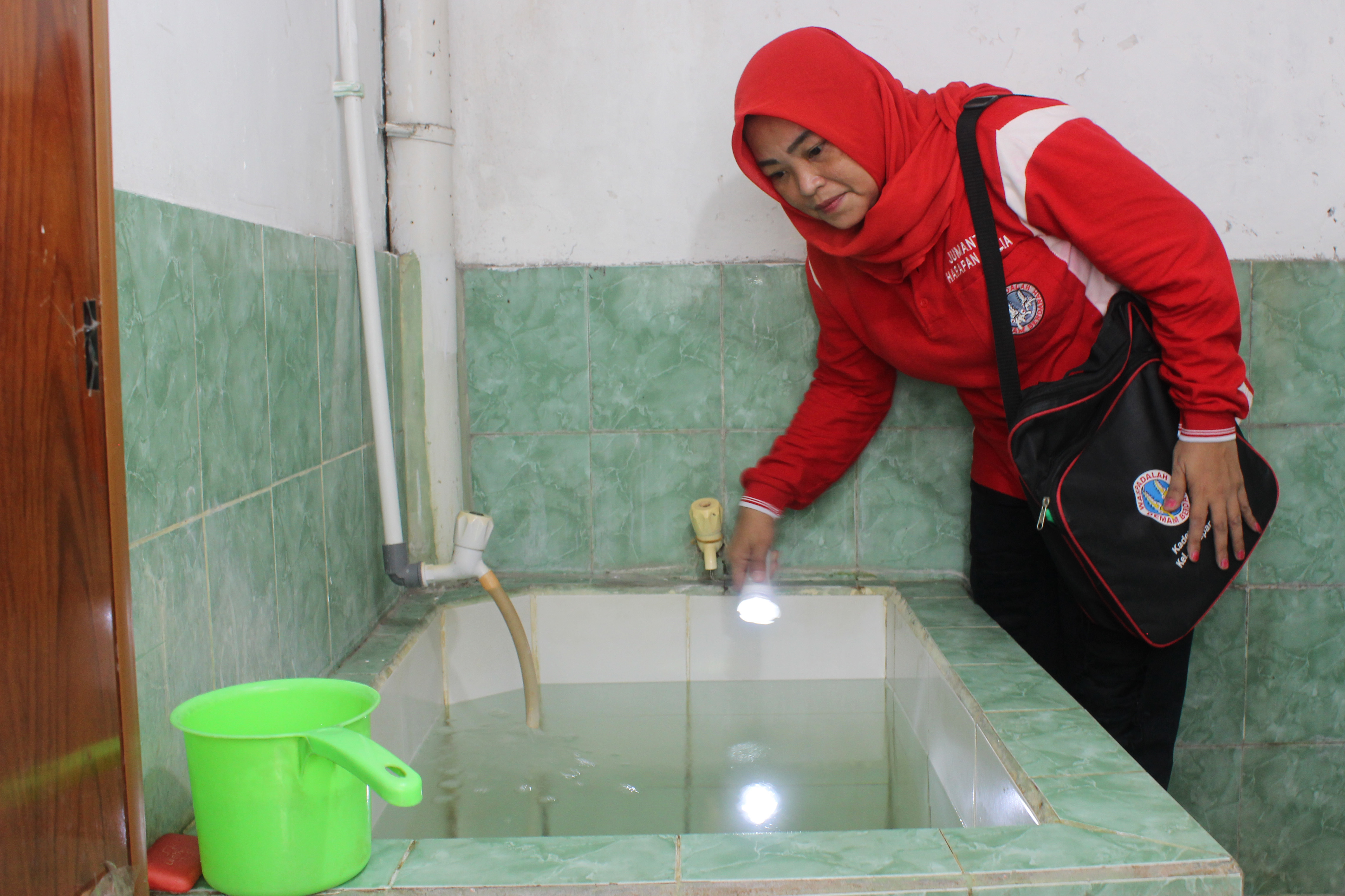 Seorang kader Jumantik memeriksa bak penampungan air di sebuah rumah ibadah di Harapan Mulya, Kemayoran, Jakarta, Rabu (27/7/2022).