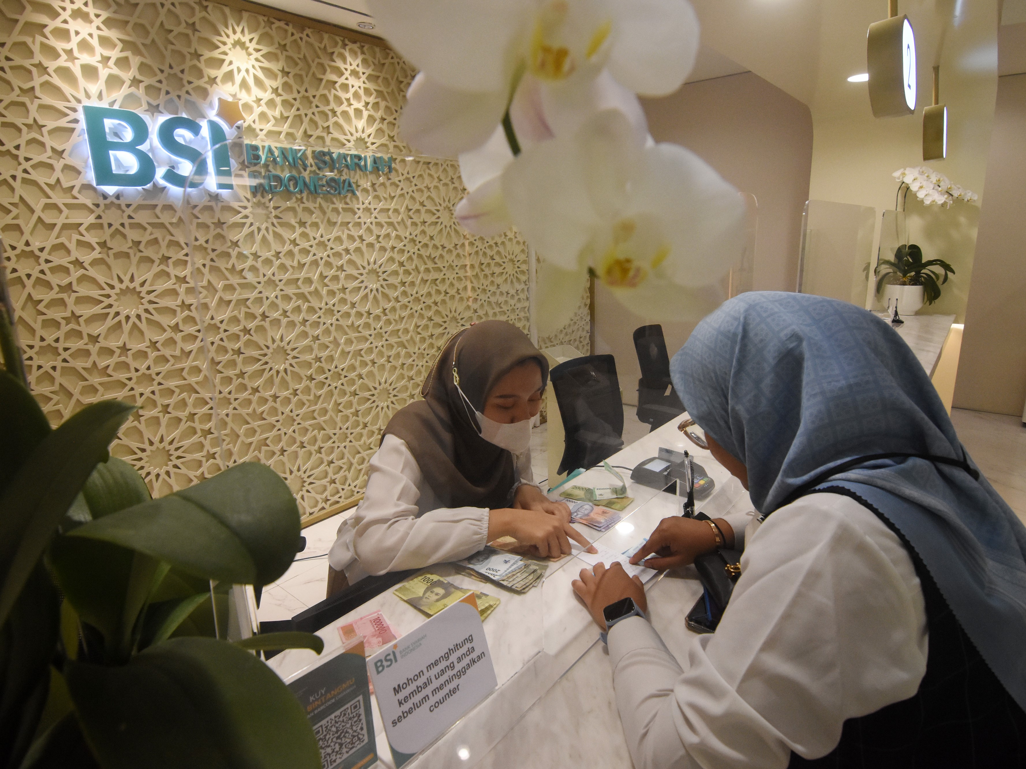 Teller melayani nasabah yang melakukan pembukaan rekening di Bank Syariah Indonesia Kantor Cabang The Tower, Jakarta (27/4/2023).