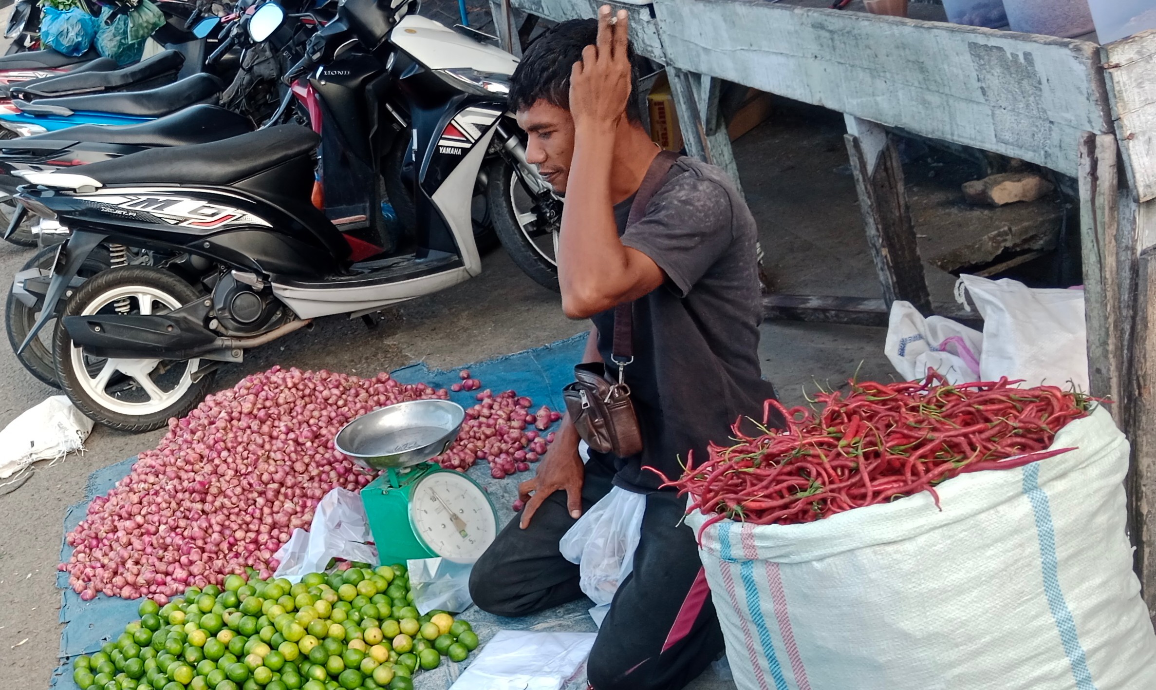 Seorang pedagang kebtuhan pokok beraktivitas di pasar
