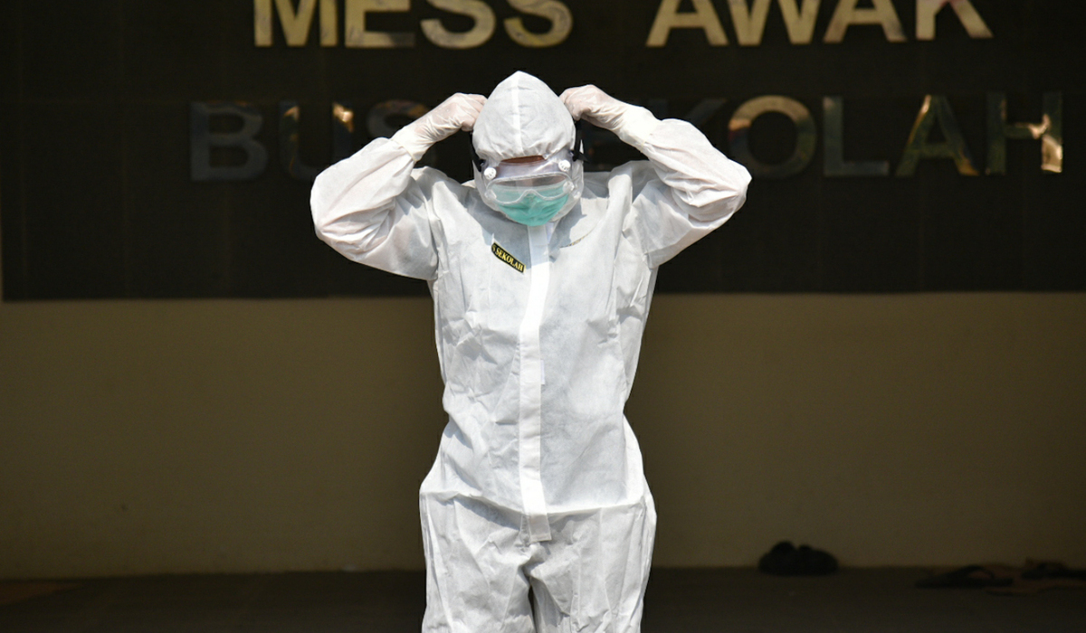 Petugas mengenakan APD bersiap diri sebelum menjemput pasien covid-19.