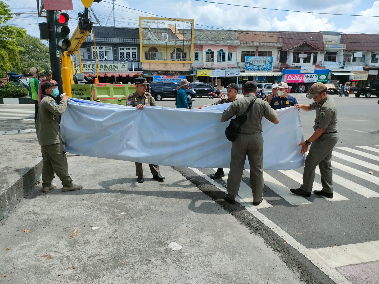 Petugas di Palangka Raya, Kalimantan Tengah menurunkan baliho caleg yang dianggap tidak memenuhi ketentuan.