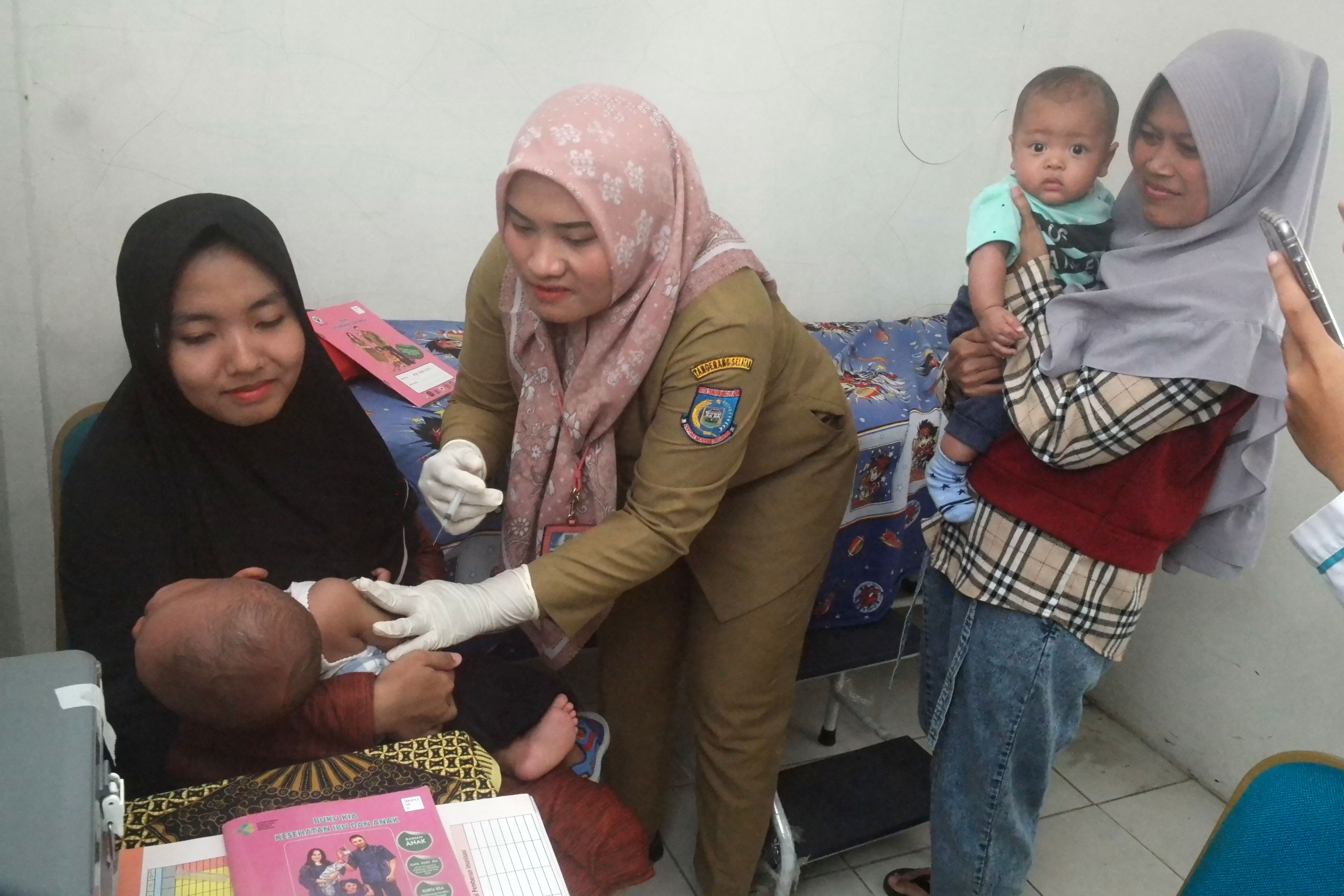 Petugas medis tengah memeriksa tumbuh kembang anak