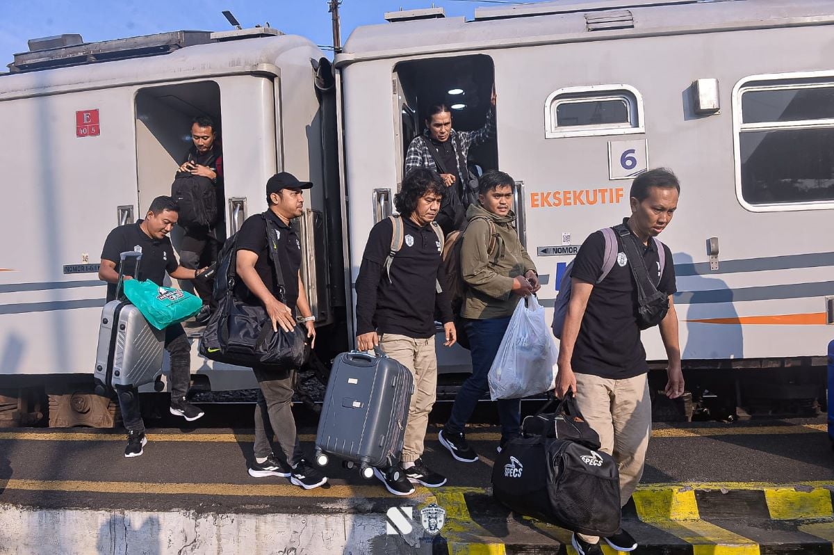 Para penumpang kereta api jarak jauh tiba di stasiun kedatangan.