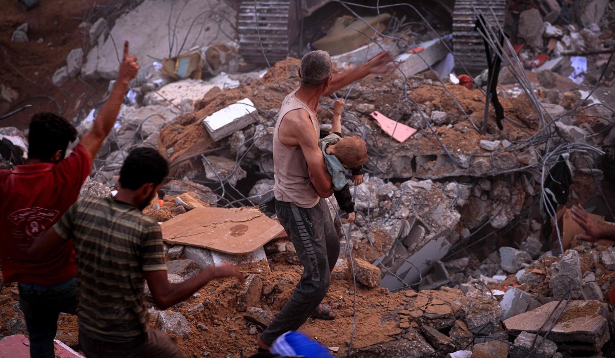 Seorang pria menggendong mayat anak yang tewas akibat serangan Israel di jalur Gaza.