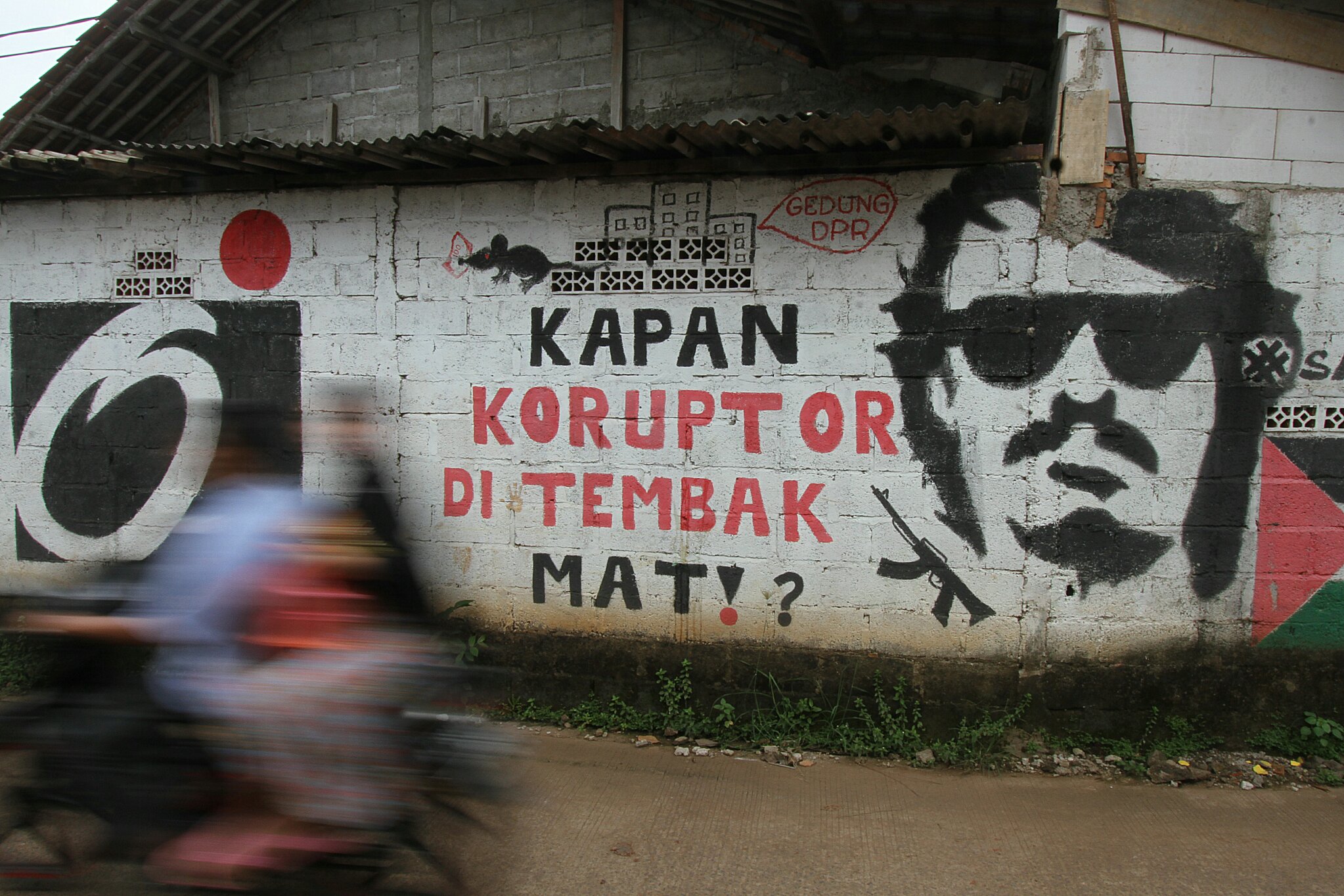Ilustrasi. Pengendara melintas di depan mural yang bertuliskan 'Kapan Koruptor Ditembak Mati?' di Jatiasih, Bekasi, Jawa Barat.
