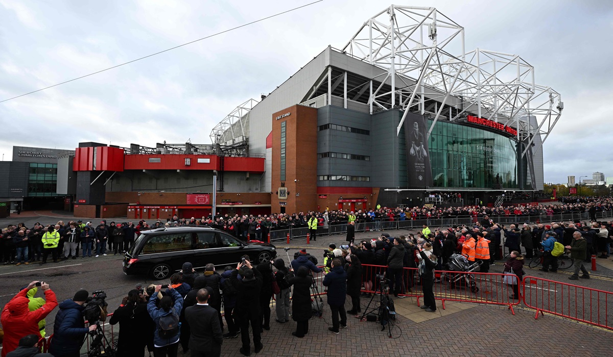 Warga memadati jalan saat mobil jenazah yang membawa Bobby Charlton melintas di depan stadion kandang Manchester United, Old Trafford.